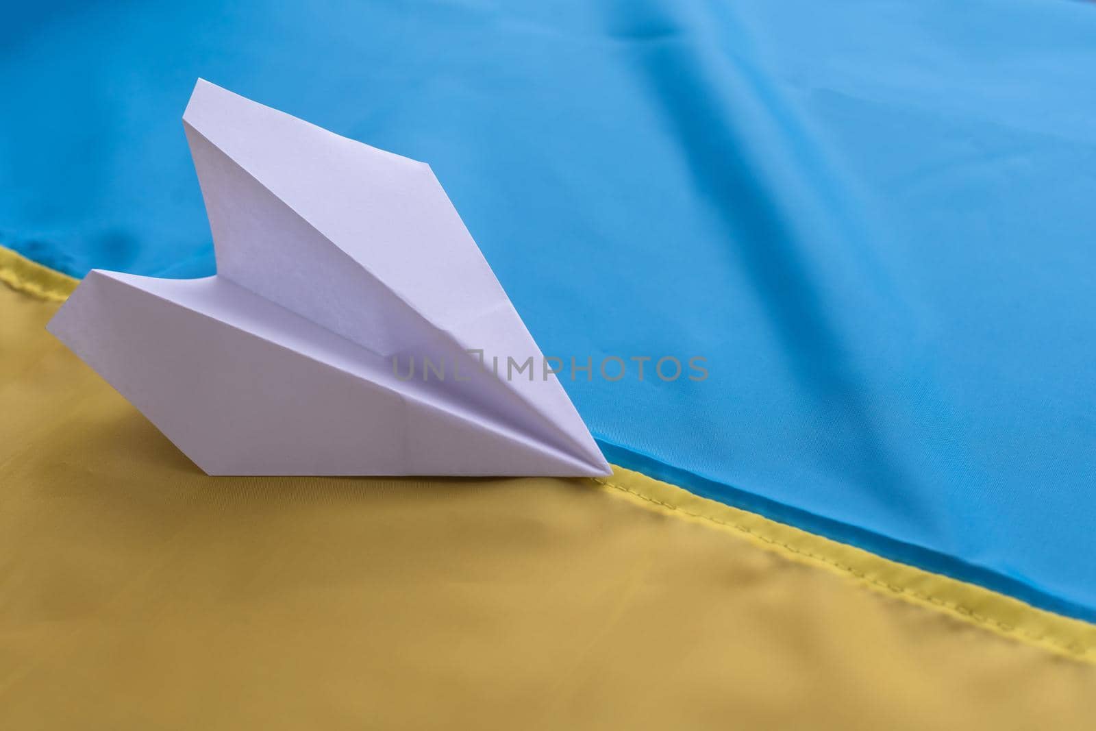 paper airplane on the background of the flag of Ukraine.