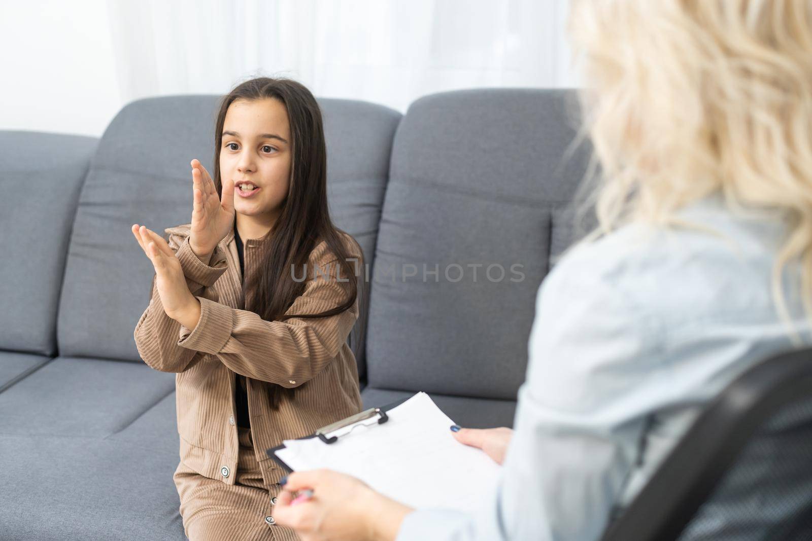 Meeting of pre-teen child girl and female social worker psychologist teacher at office.