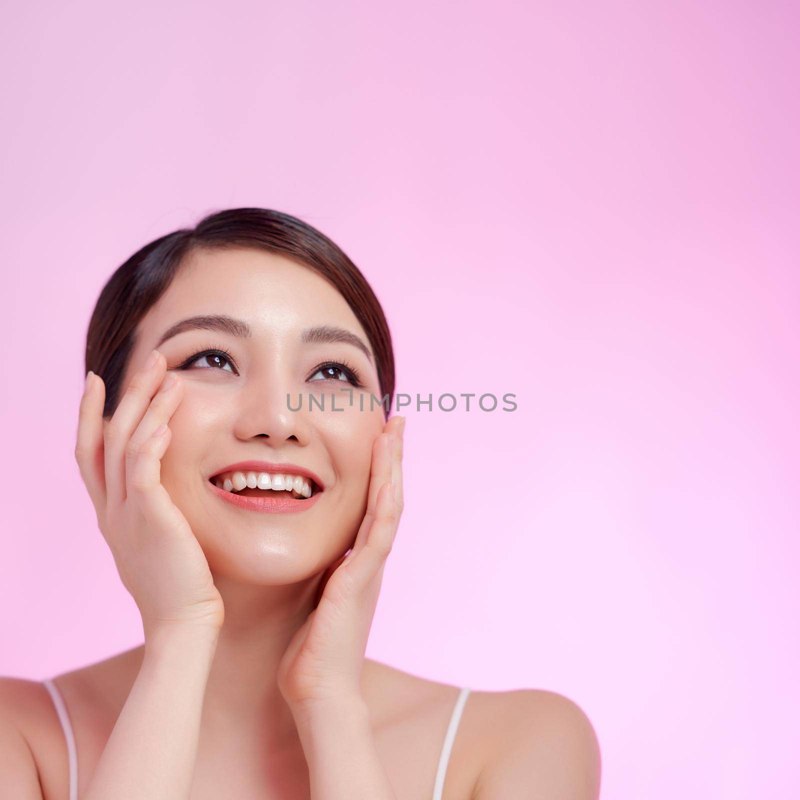 Beautiful woman face close up studio on pink.