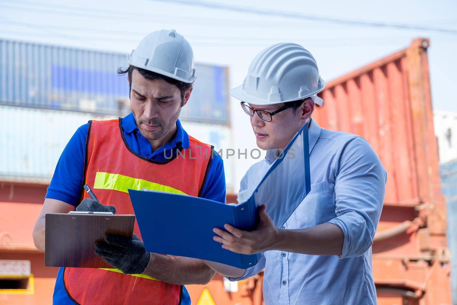 Foreman and cargo container worker discuss together with document in workplace area. Concept of good management system and teamwork in delivery business.