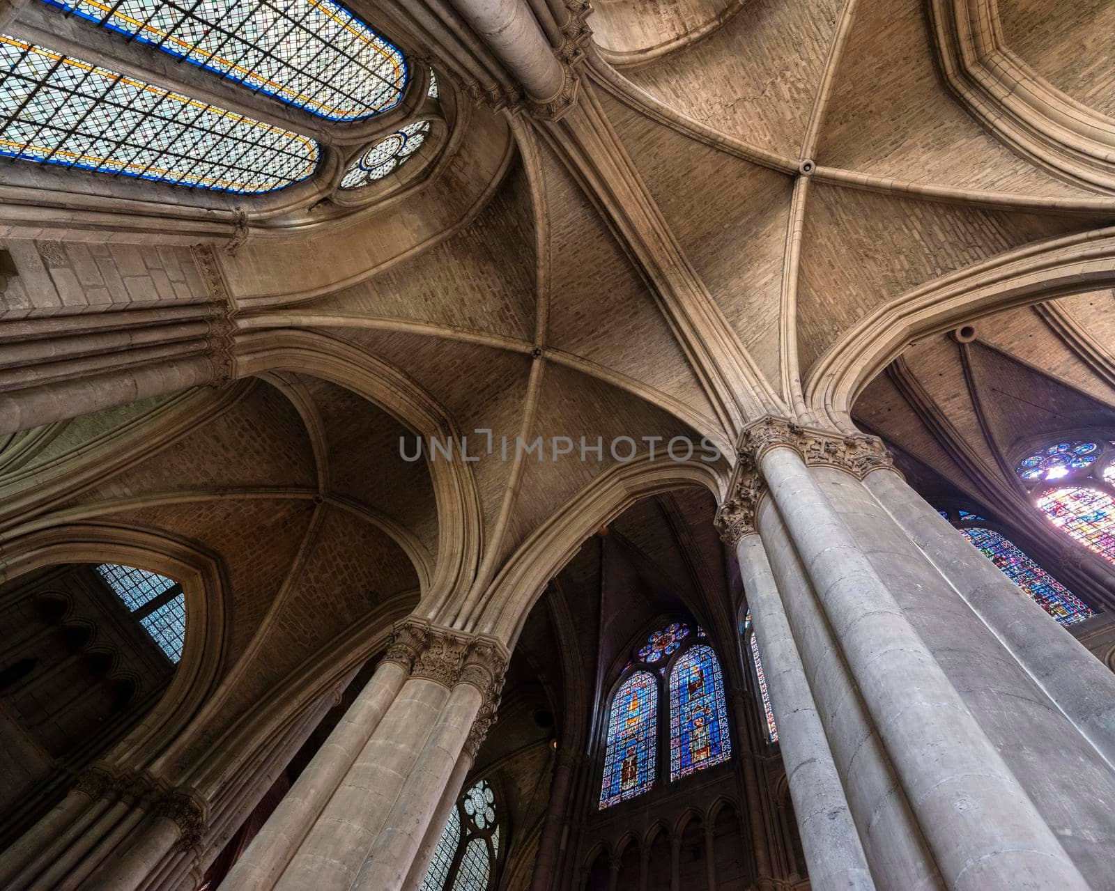 vaults, pillars and stained glass windows inside cathedral of reims in the north of france