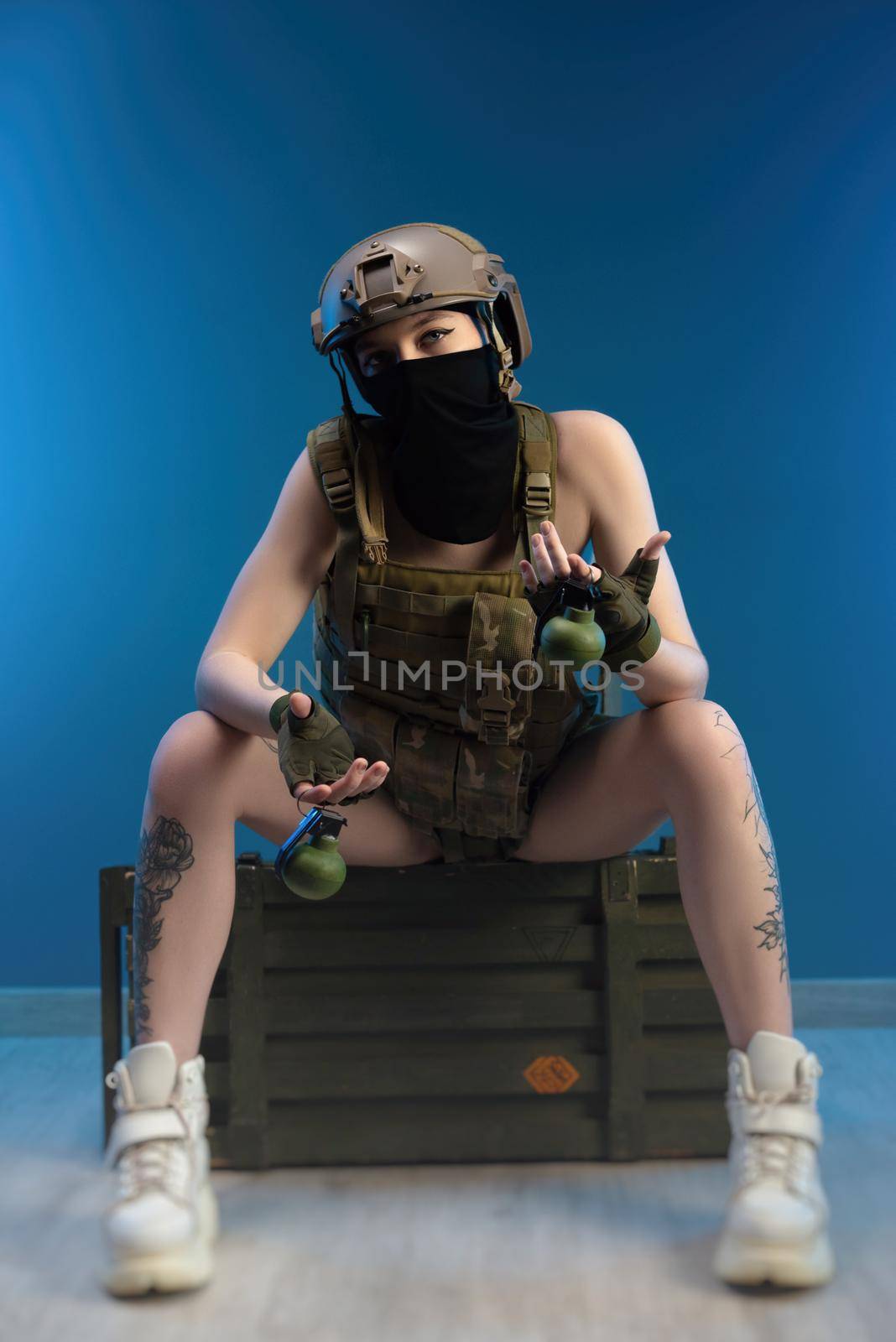 sexy girl soldier in helmet and bulletproof vest in military clothes with grenades posing in the studio by Rotozey