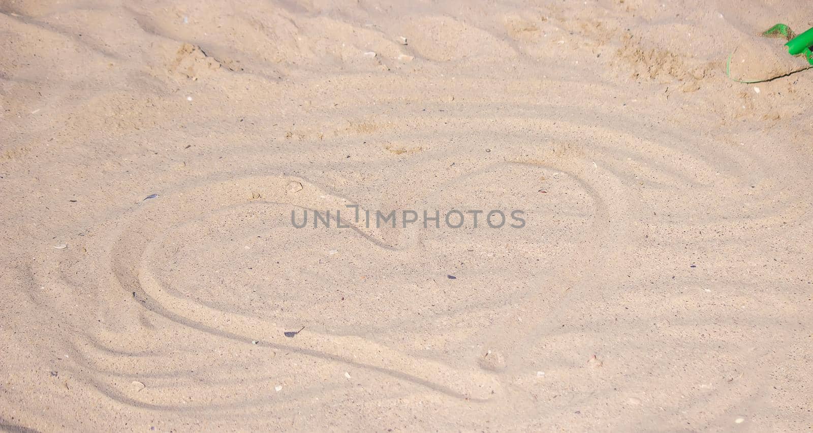 Heart drawn in the sand. Beach background. Top view. selective focus
