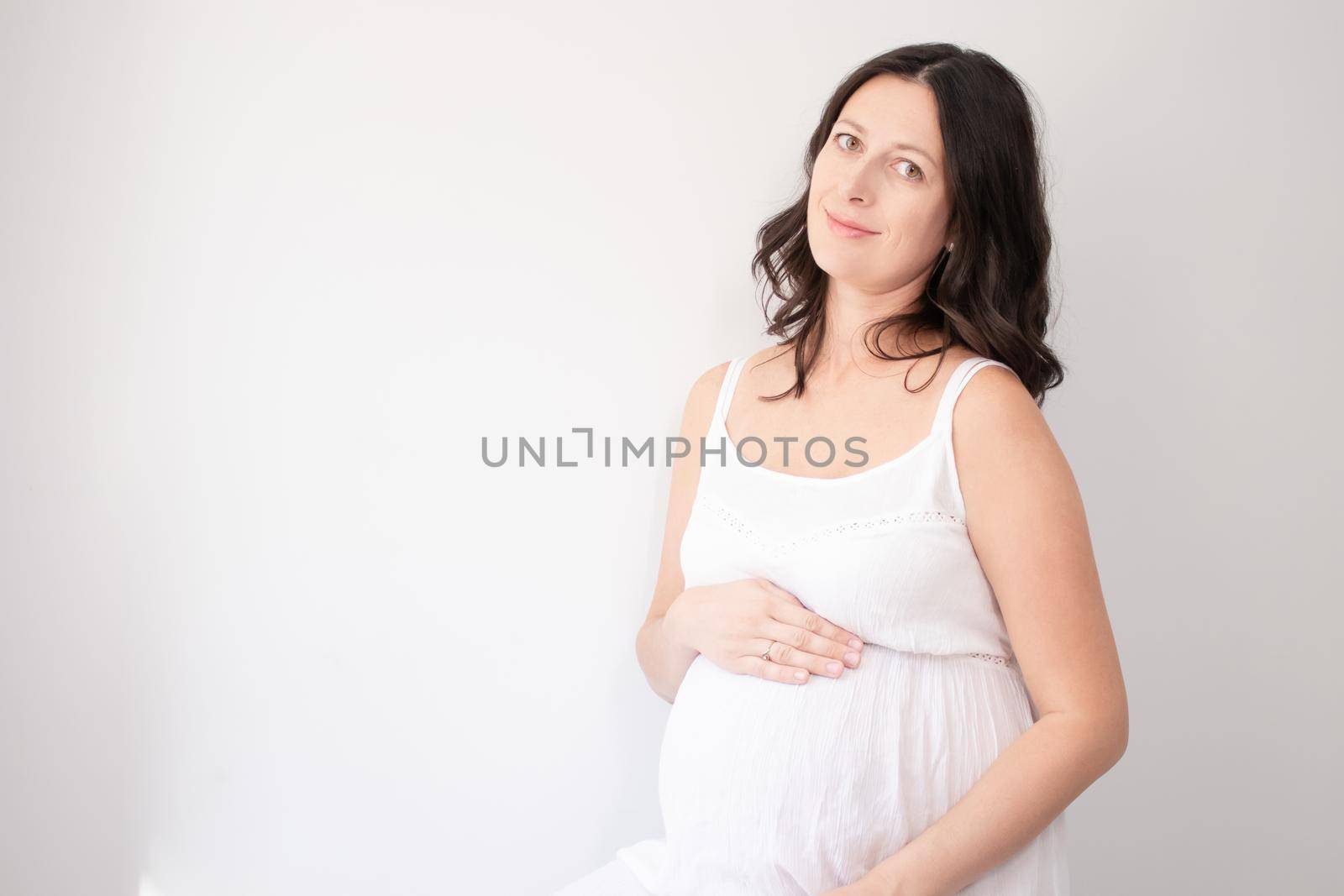 expecting mother with huge tummy. sweet pregnancy time. happy woman with pregnant belly in light bedroom. home cozy interior