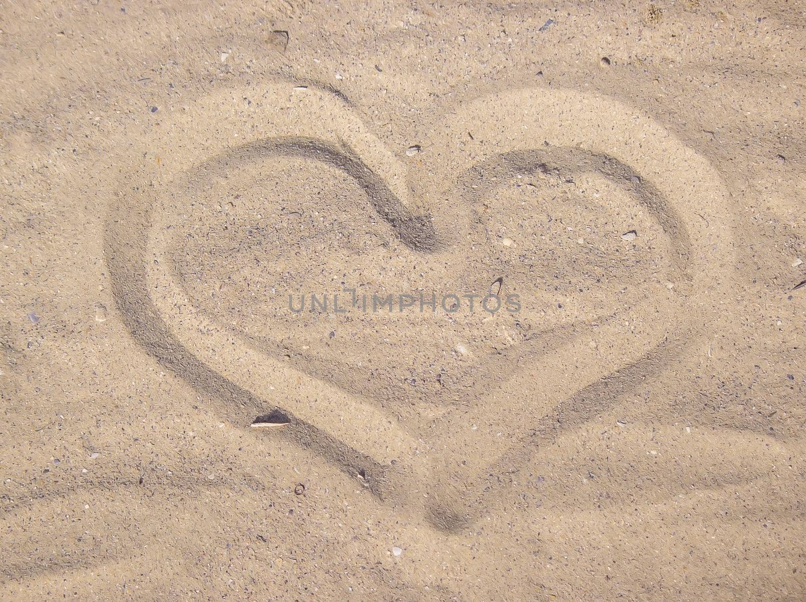 Heart drawn in the sand. Beach background. Top view. selective focus