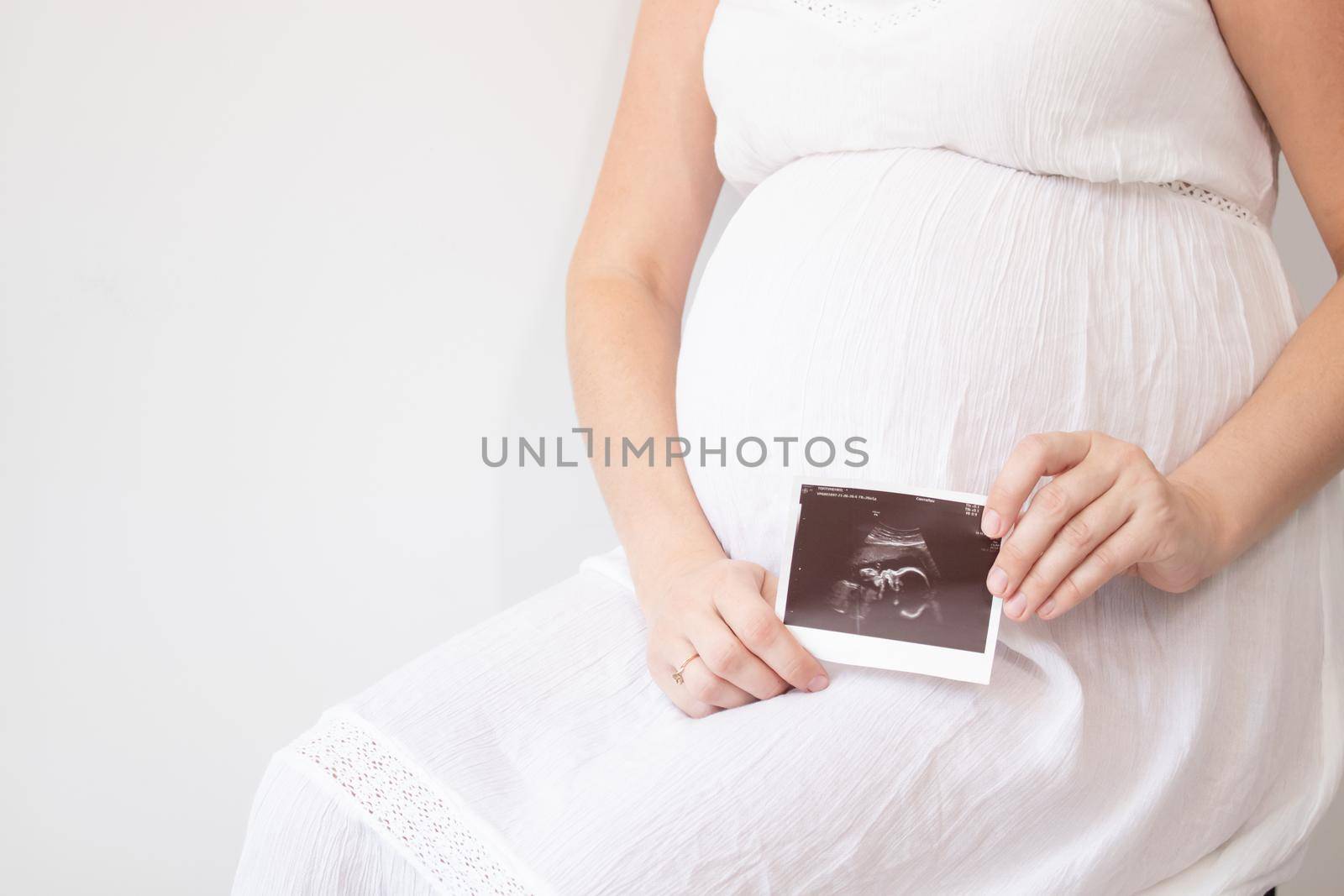 pregnant woman with a photo of ultrasound of pregnancy. enjoying pregnancy happy time. mother to be with cute big tummy.