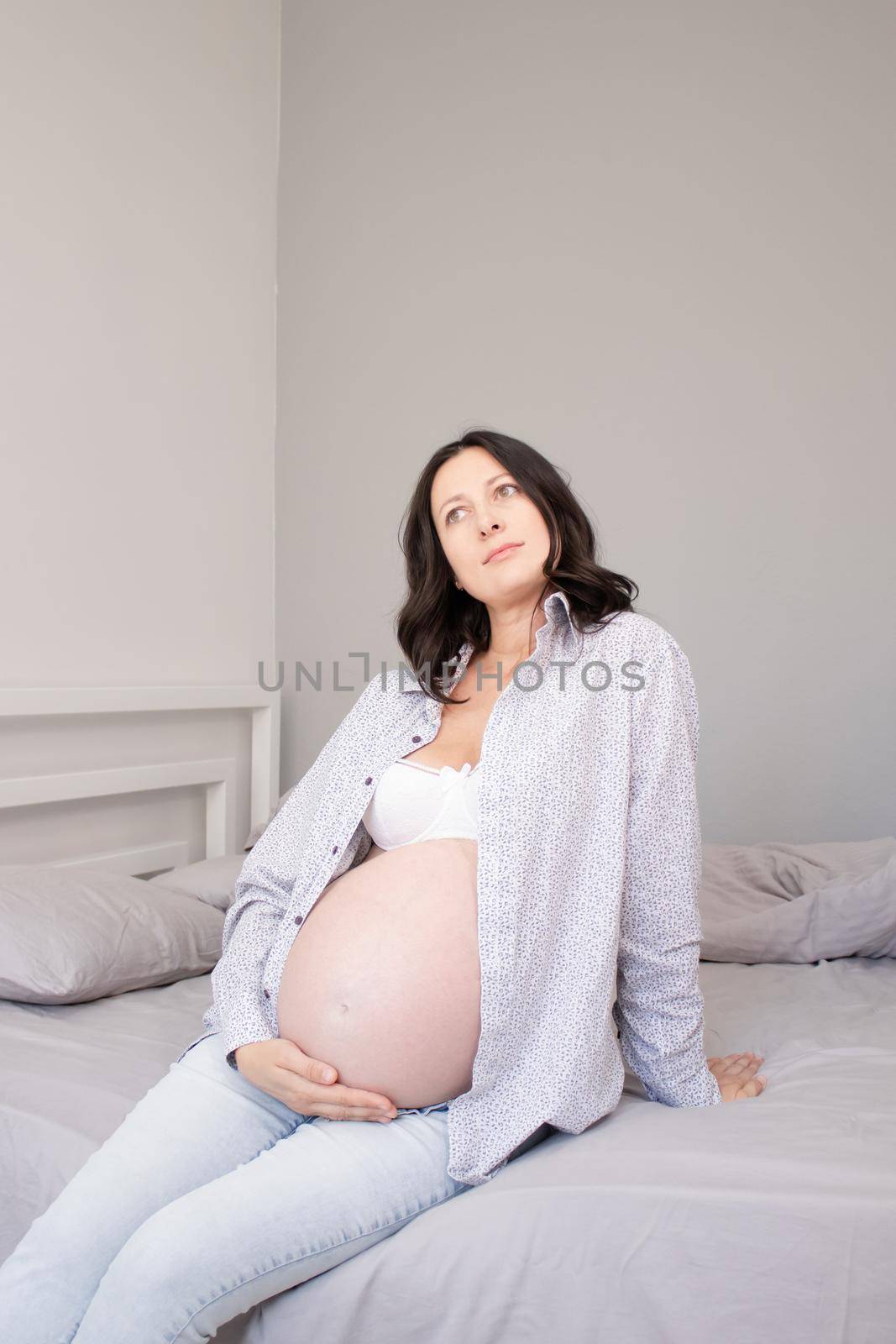 mother to be on bedchamber. pretty woman with big tummy. expecting parent mother. happy motherhood.