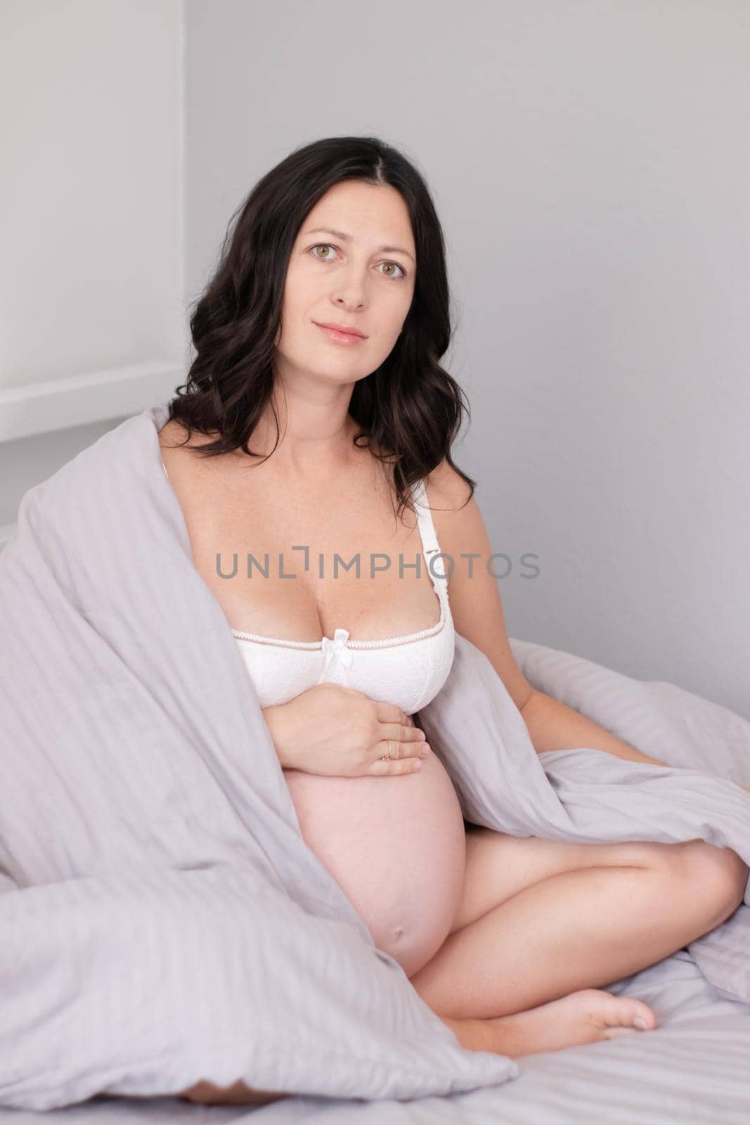 expecting mother with huge tummy. sweet pregnancy time. happy woman with pregnant belly in light bedroom. home cozy interior