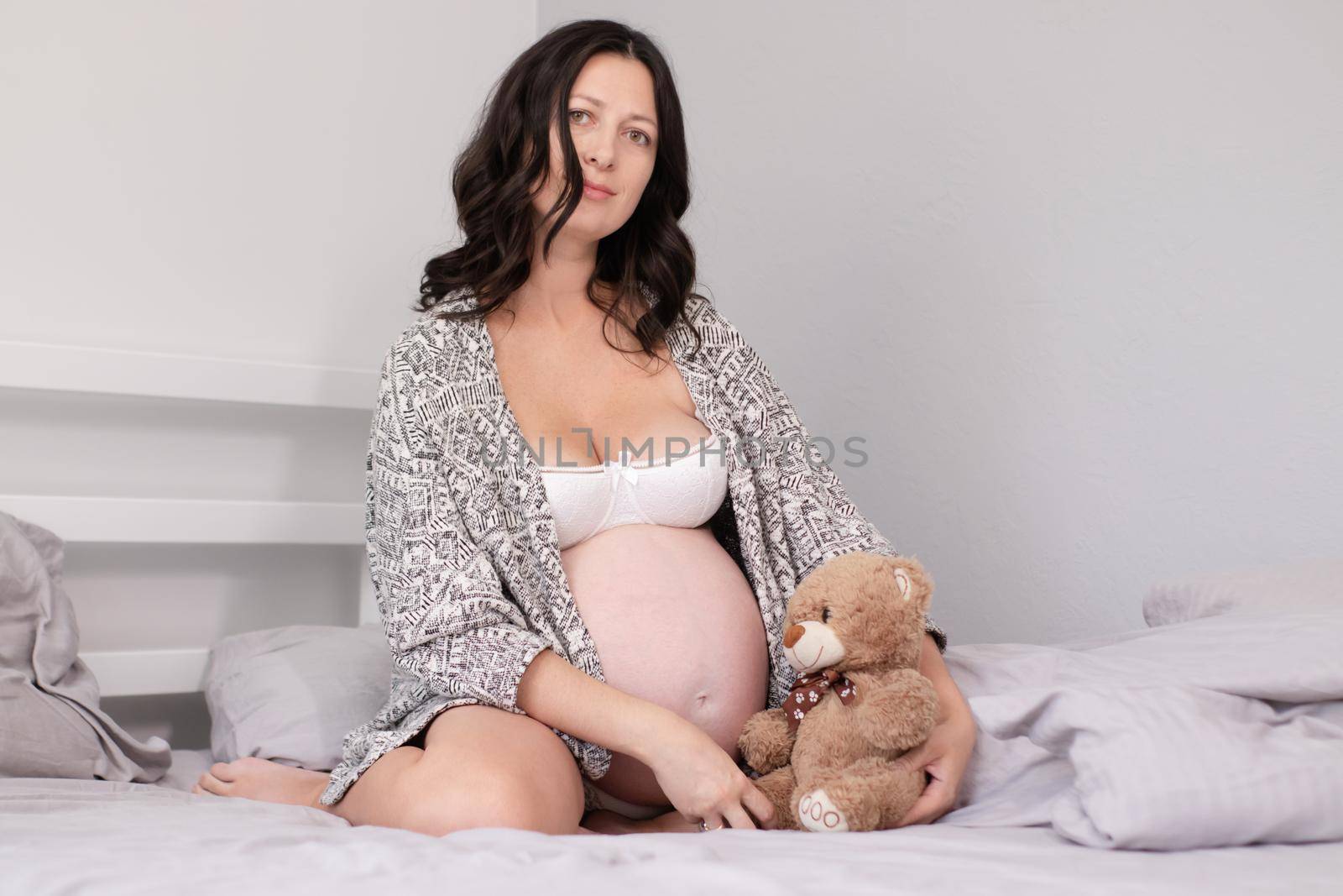 expecting mother with huge tummy. sweet pregnancy time. happy woman with pregnant belly in light bedroom. home cozy interior