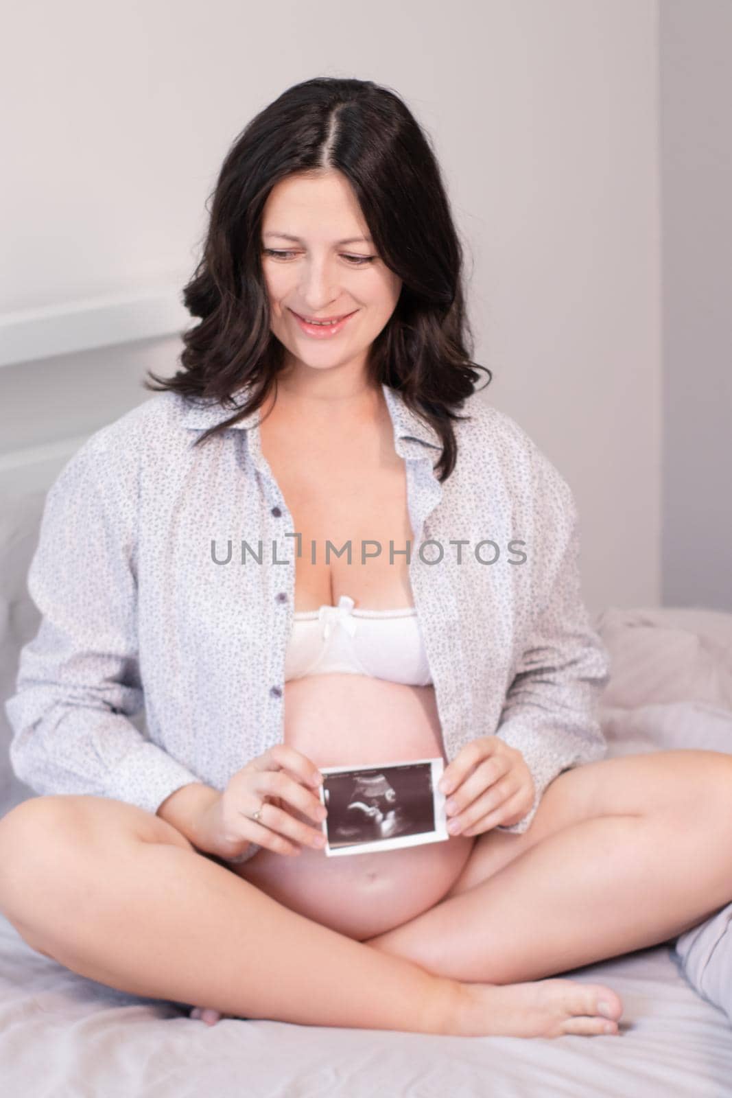 pregnant woman with a photo of ultrasound of pregnancy. enjoying pregnancy happy time. mother to be with cute big tummy by oliavesna