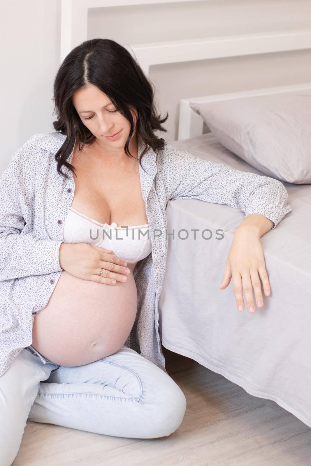 mother to be on bedchamber. pretty woman with big tummy. expecting parent mother. happy motherhood.