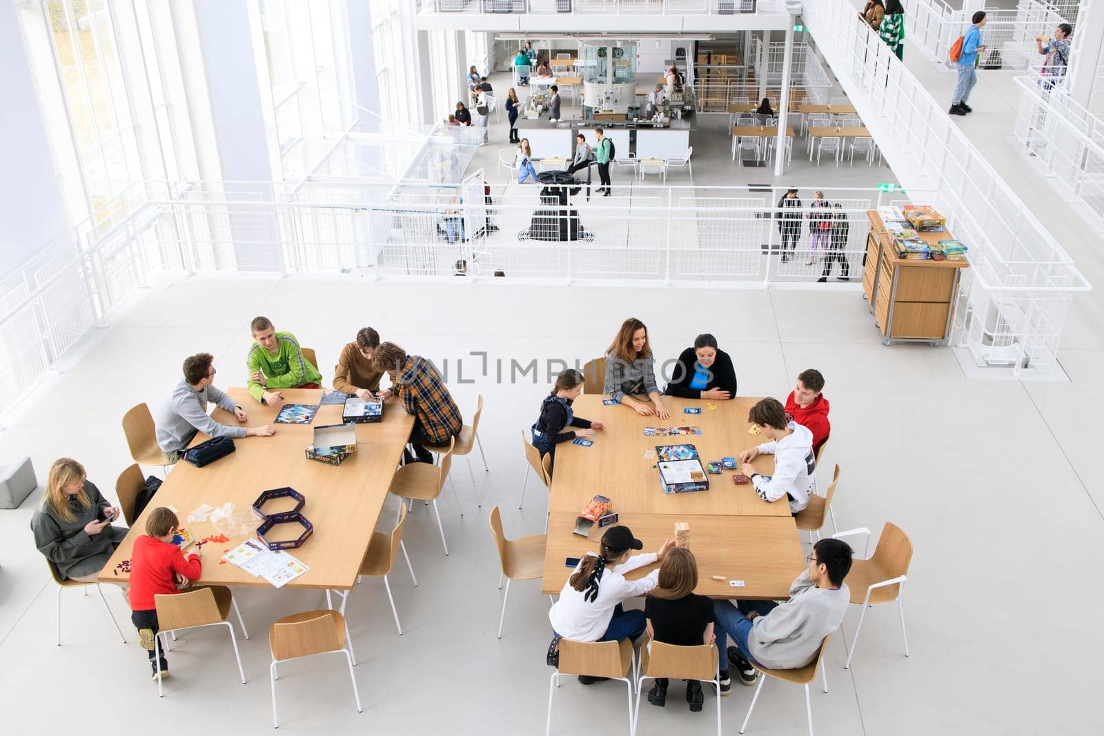 Interior of GES-2, also known as MGES-2 and Tramvaynaya is a decommissioned power station on the Bolotnaya Embankment. Teenagers play board games at the tables by elenarostunova