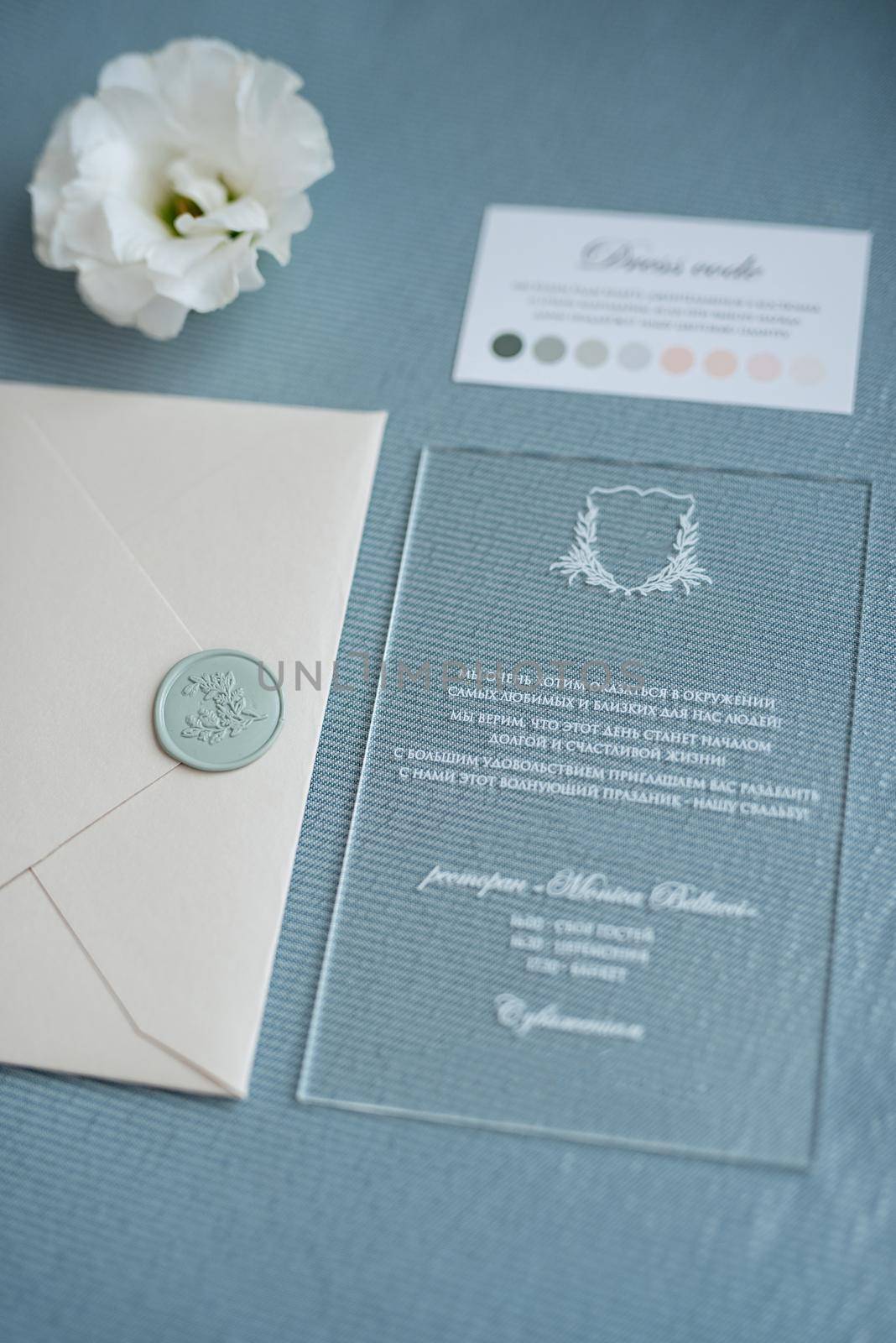 wedding invitation in a gray envelope on a table with green sprigs