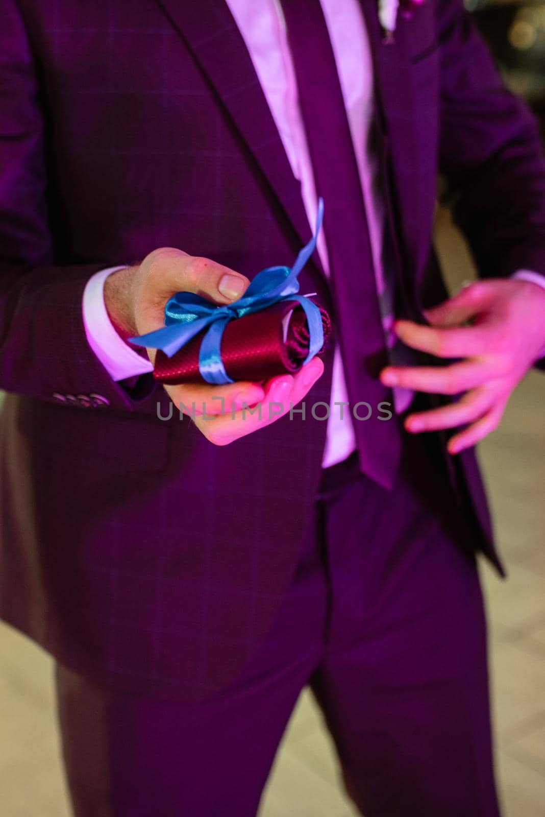 folded tie in the groom's hand before throwing