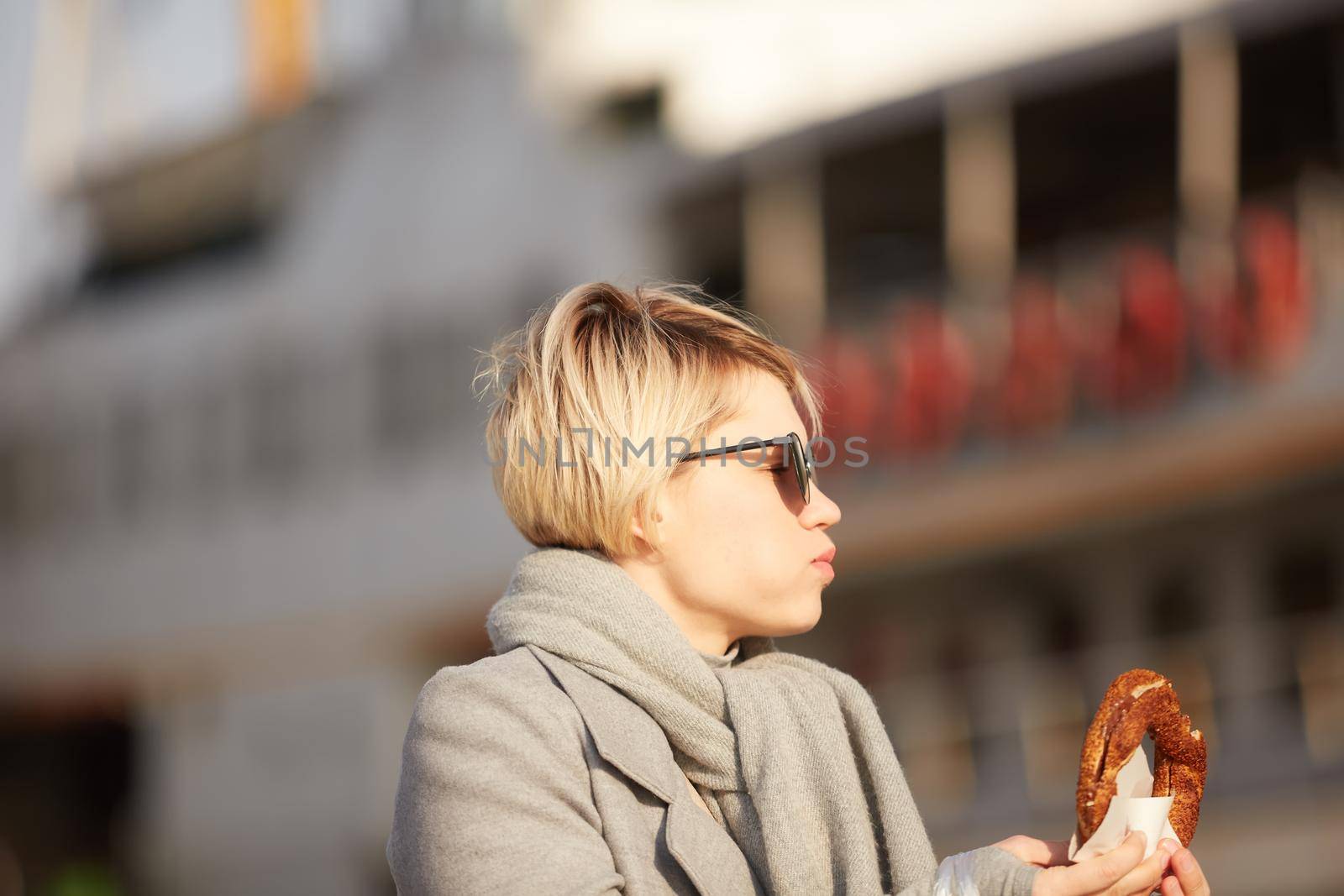 Young woman eating turkish bagel in Istanbul, Turkey. Traditional turkish street food