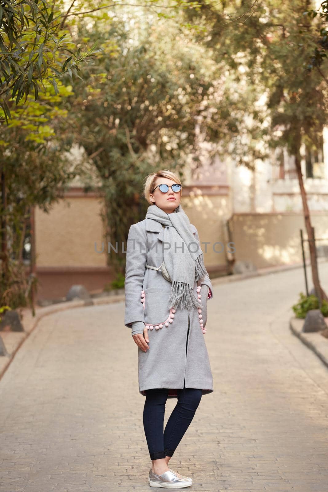 Young blond woman with sunglases on the street by sarymsakov