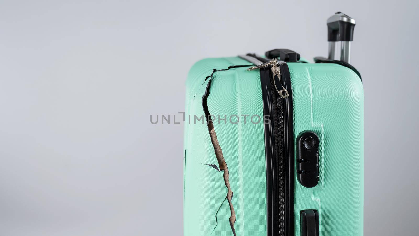 Close-up of a broken plastic suitcase on a white background