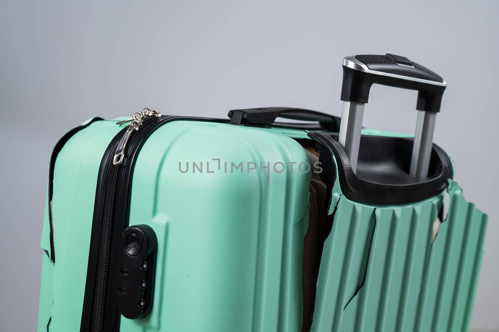 Close-up of a broken plastic suitcase on a white background