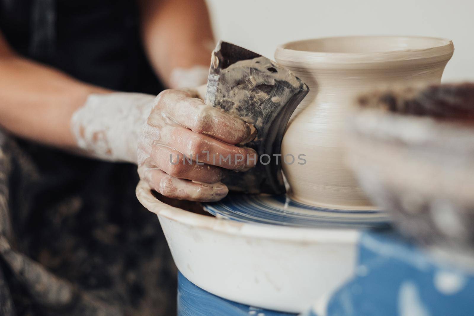 Close Up of Pottery Artist at Work, Potter Master Creating Clay Pot on a Wheel by Romvy