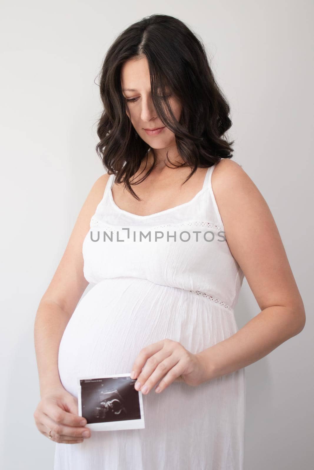 pregnant woman with a photo of ultrasound of pregnancy. enjoying pregnancy happy time. mother to be with cute big tummy by oliavesna