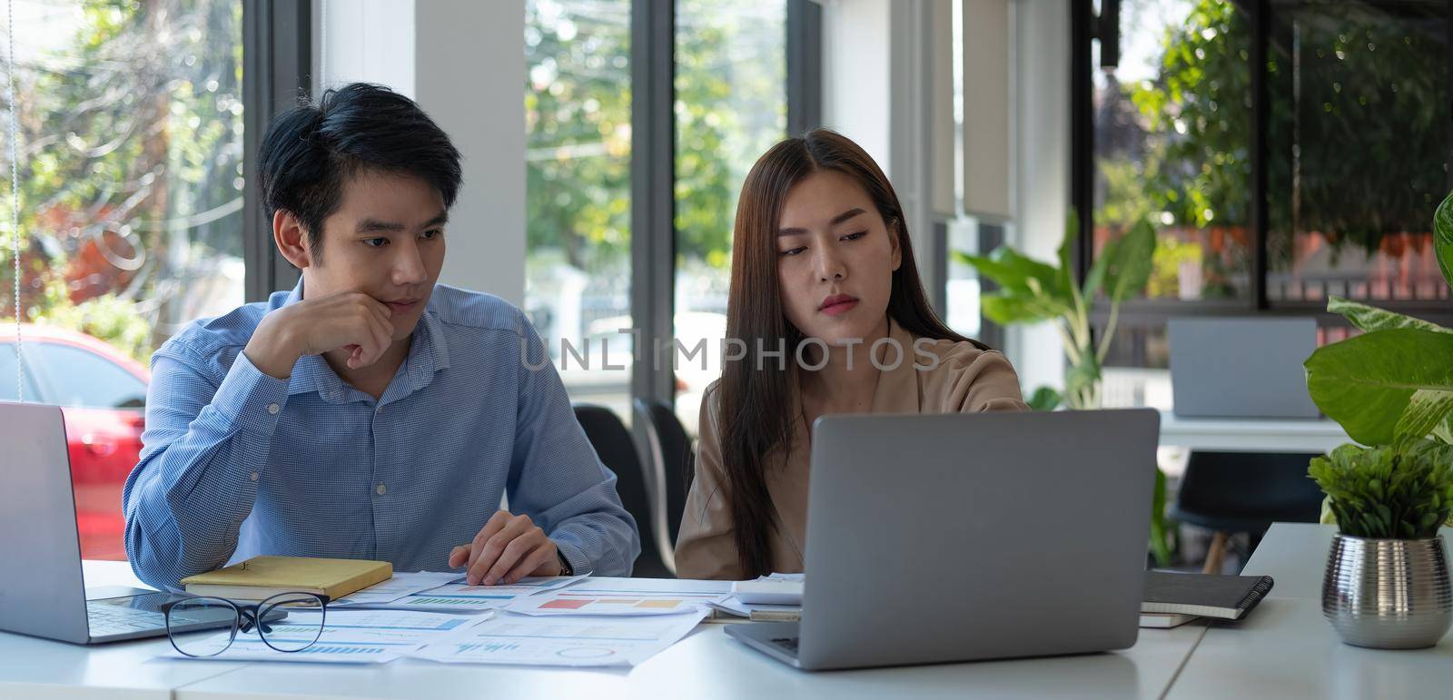 business partnership coworkers discussing a financial planning graph and company during a budget meeting in office room by nateemee