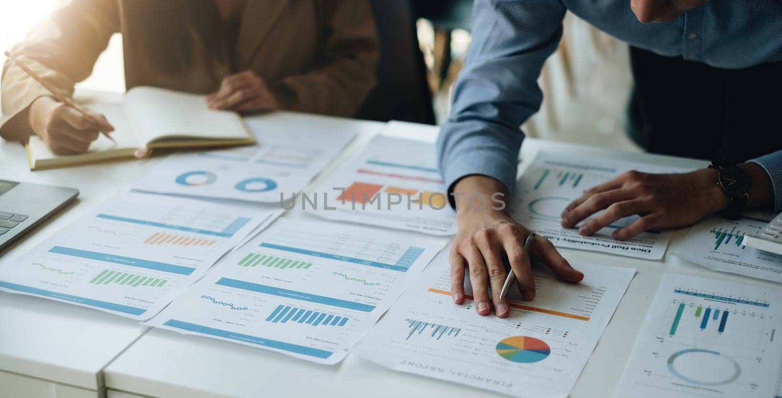 Two business asian people working in the office discussing documents and ideas from financial report paperwork at meeting.