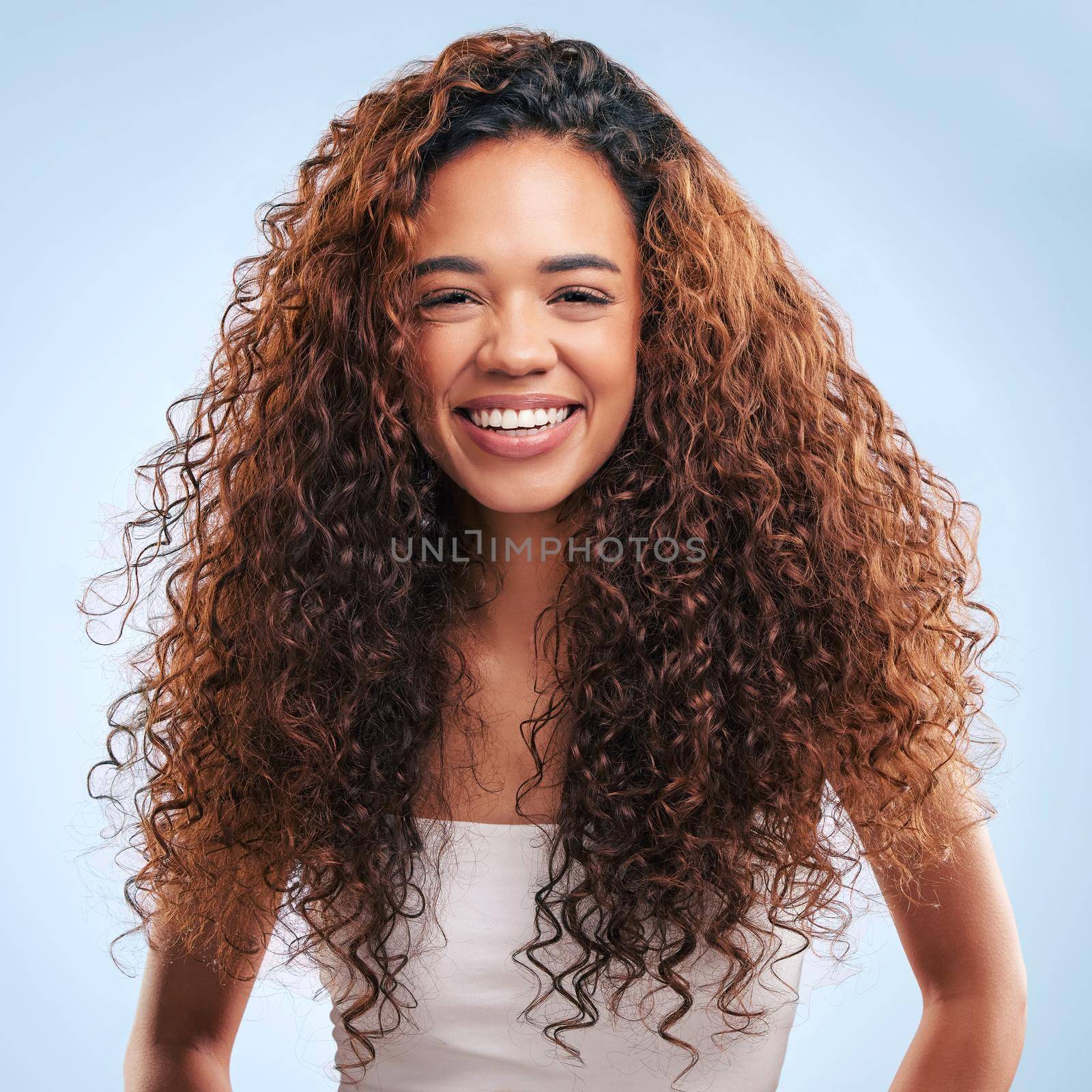 Cropped portrait of an attractive young woman posing in studio against a grey background.