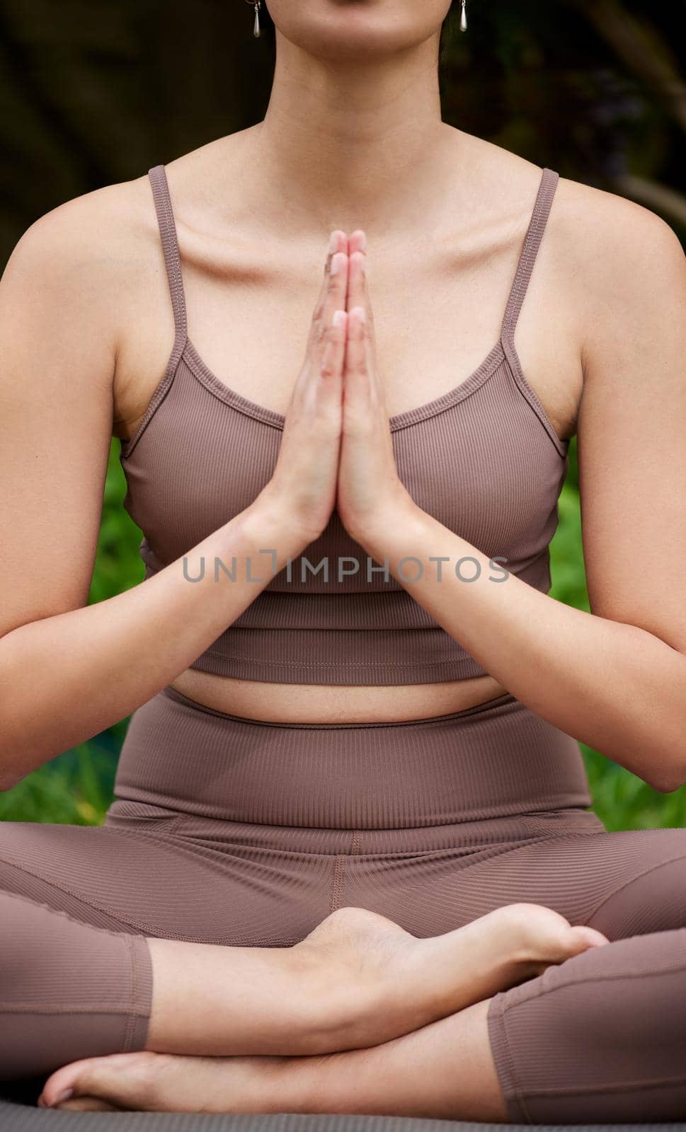 Closeup shot of an unrecognisable woman meditating outdoors.