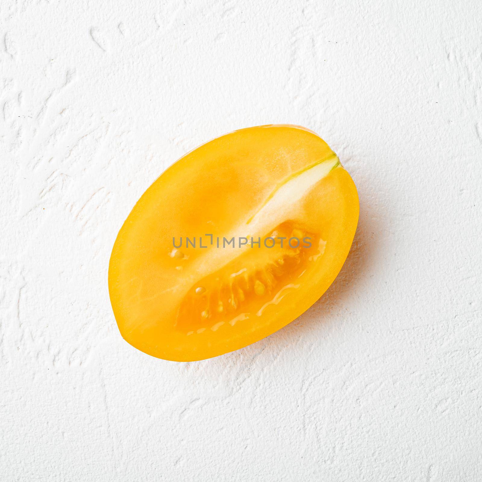 Yellow tomato, on white stone table background, square format, top view flat lay by Ilianesolenyi