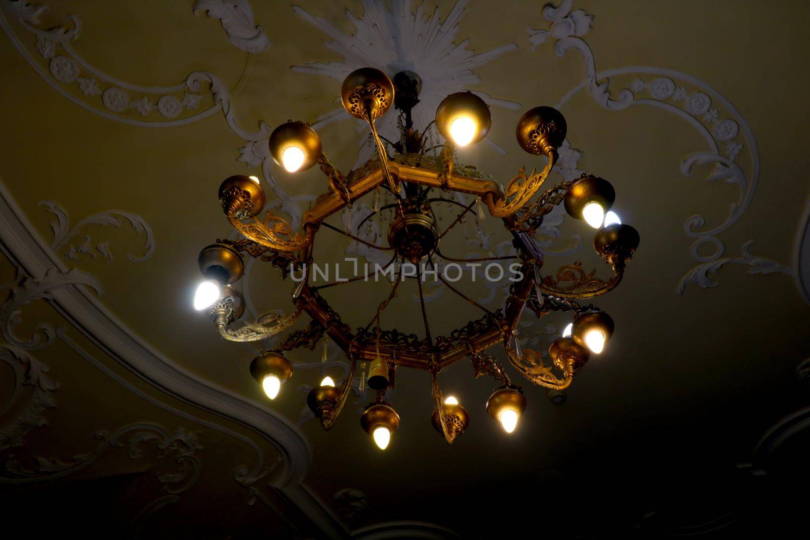 A beautiful old metal chandelier hangs from the ceiling. by kip02kas