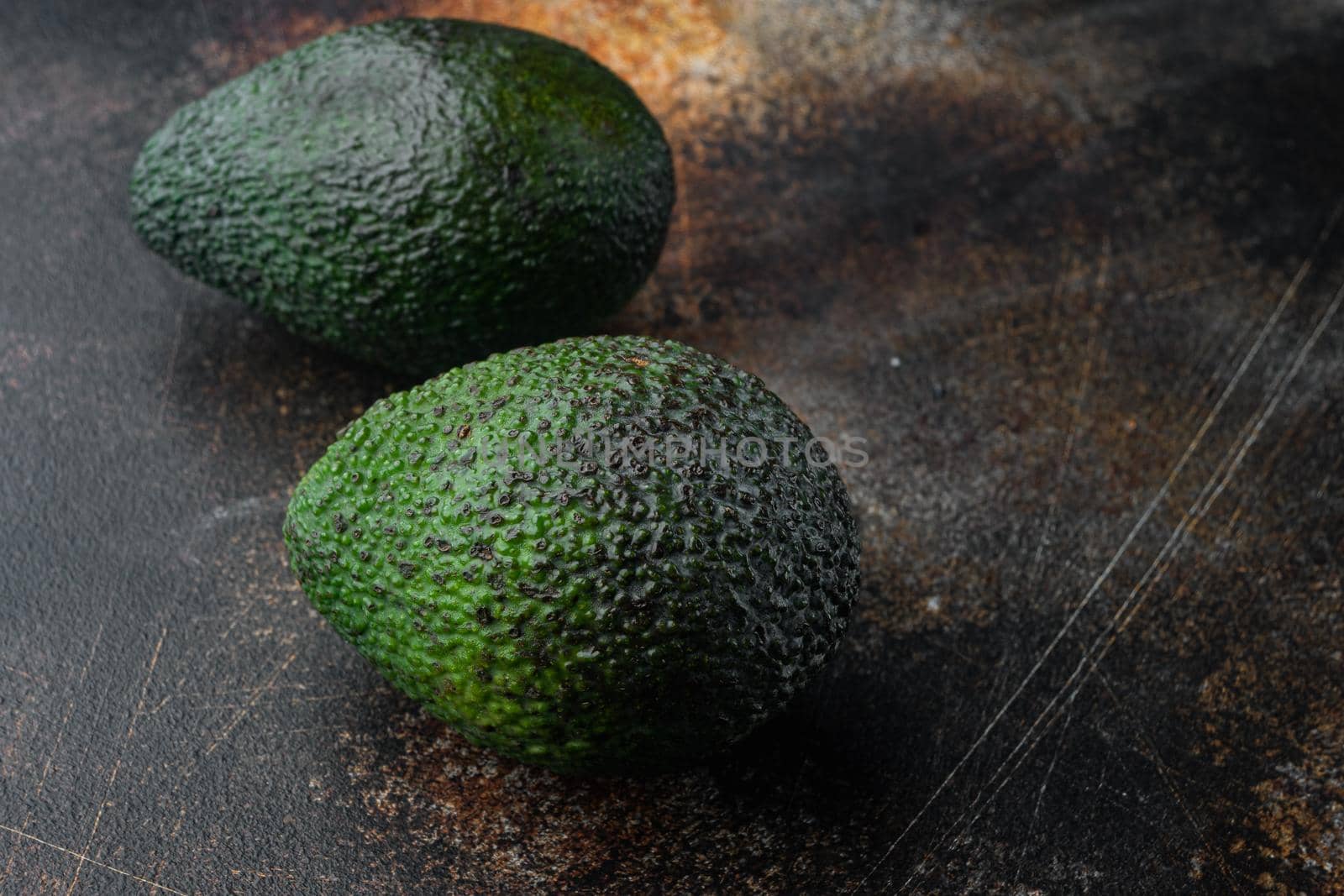 Ripe pair of green avocado set, on old dark rustic background with copy space for text