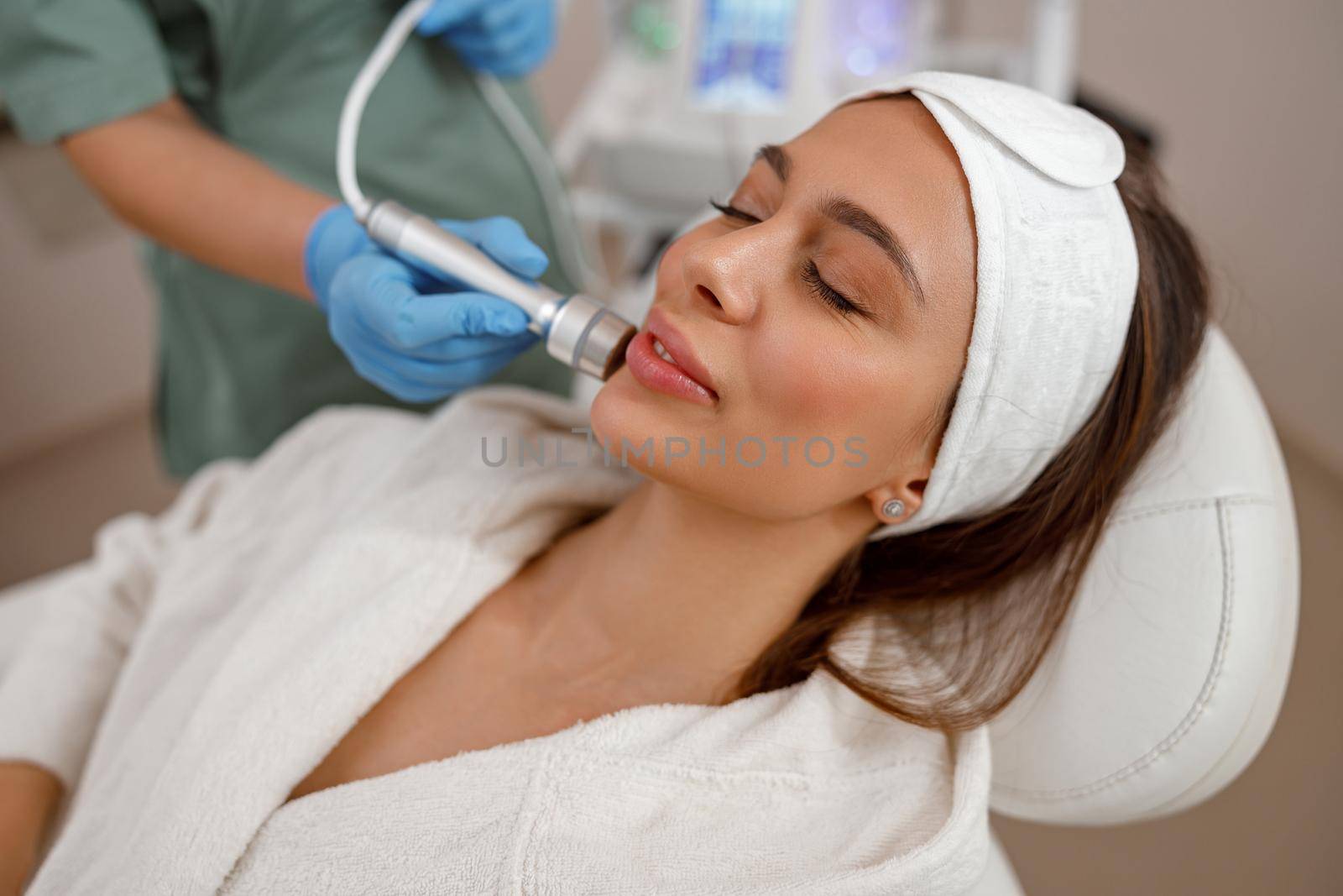 Female client getting aesthetic facial skin treatment in beauty salon by Yaroslav_astakhov