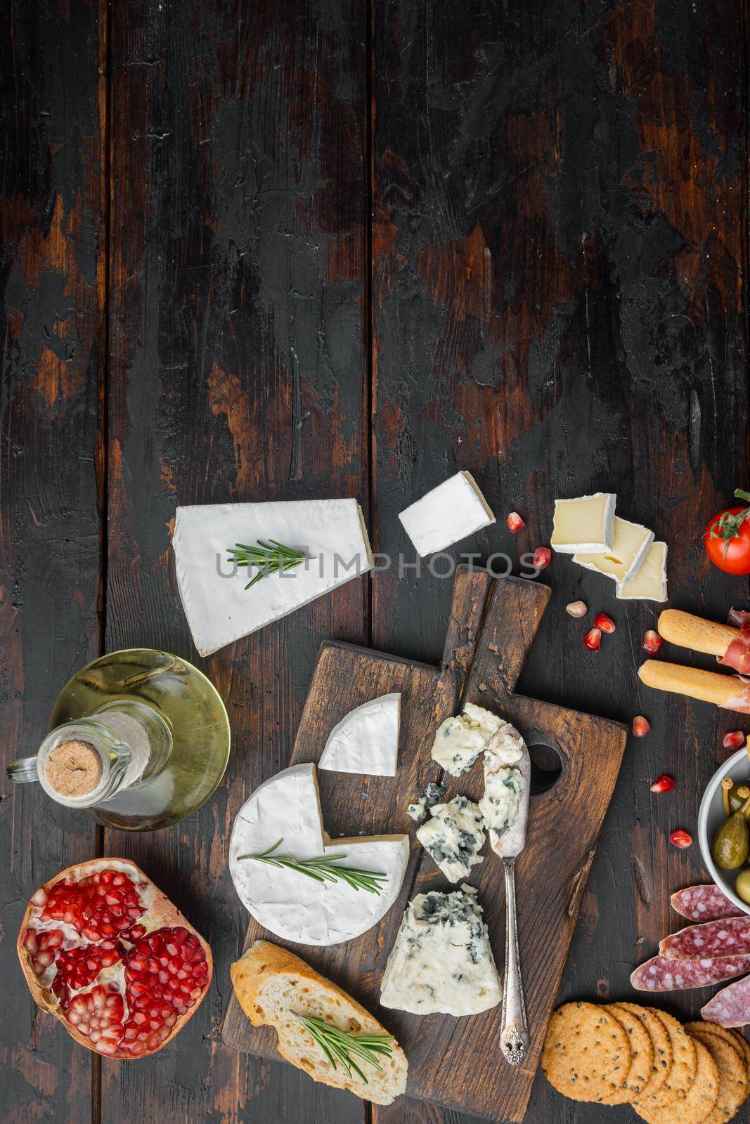 Appetizers table with differents antipasti set, on dark wooden background, flat lay with copy space for text