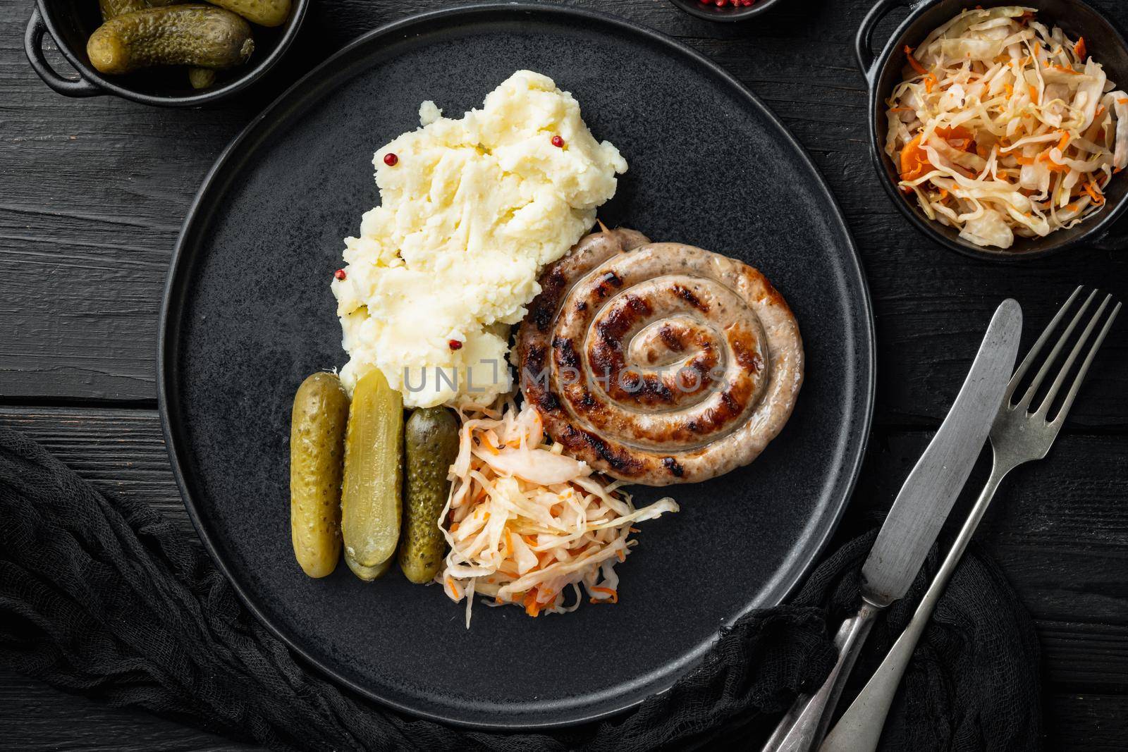 Sauerkraut with grilled sausages , on black wooden table background, top view flat lay by Ilianesolenyi