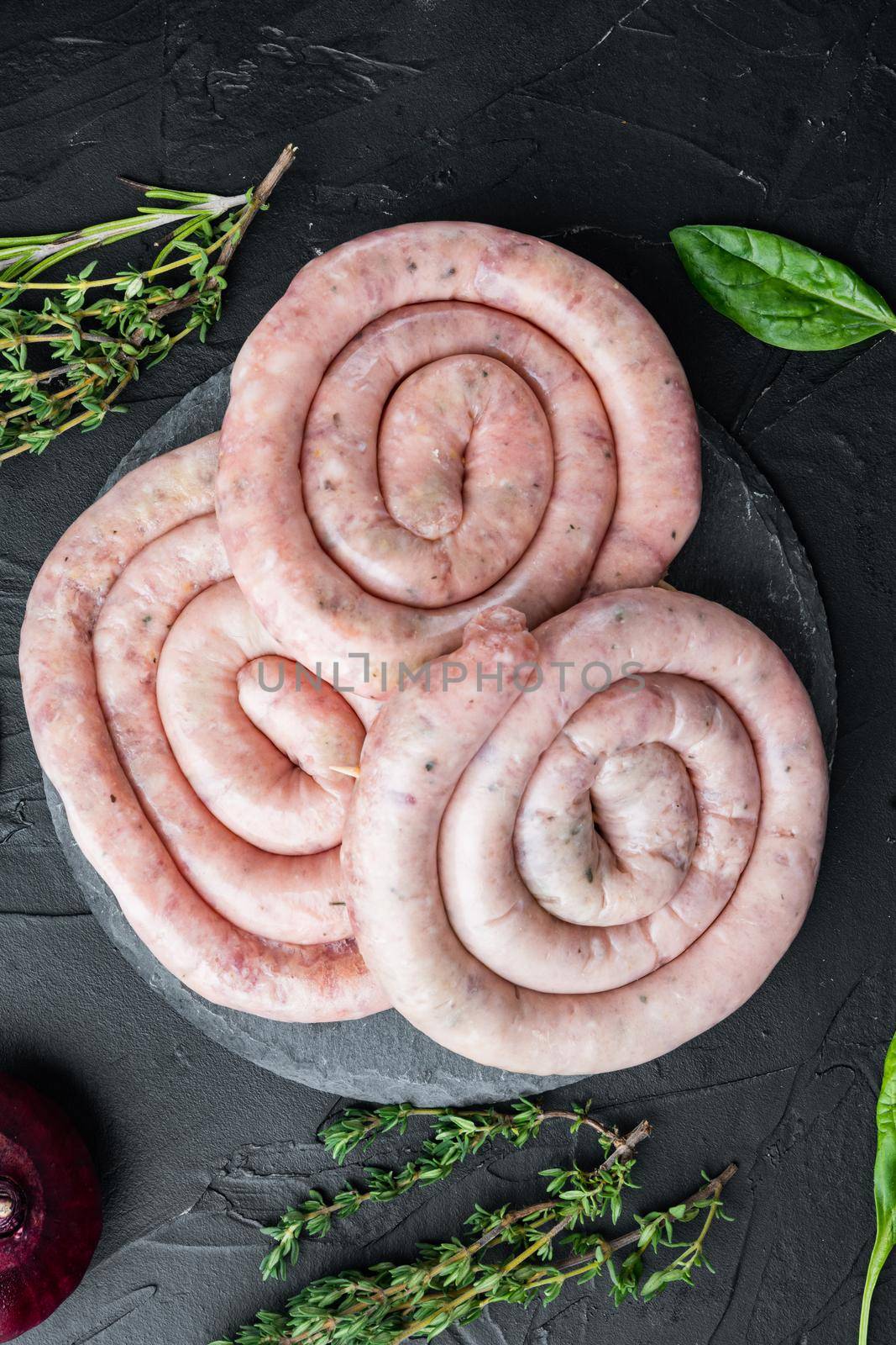 Spiral pork meat sausage, on black background, top view flat lay by Ilianesolenyi