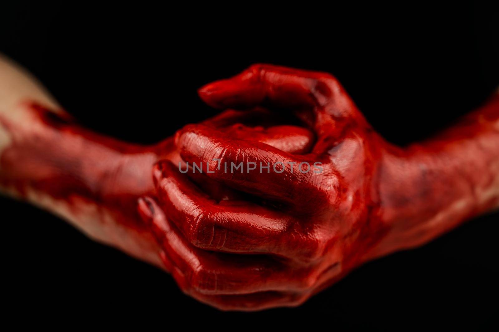 Women's fists in blood on a black background. Fist and palm