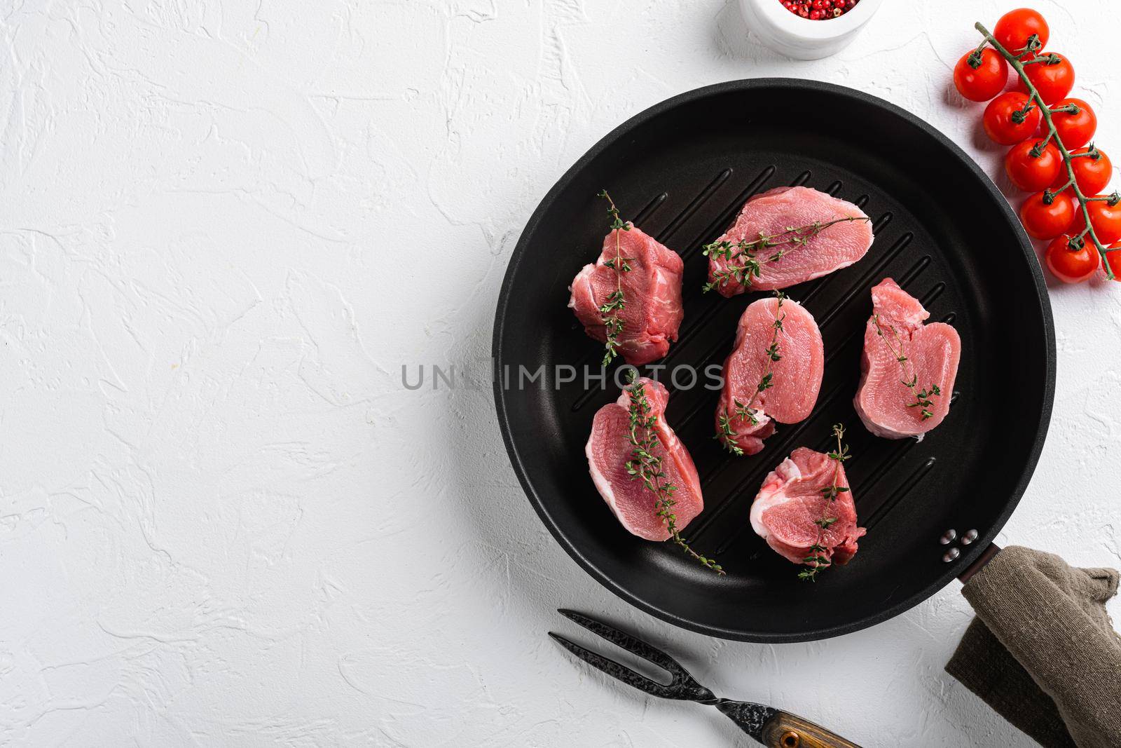 Raw pork medallion steaks, on white stone table background, top view flat lay, with copy space for text