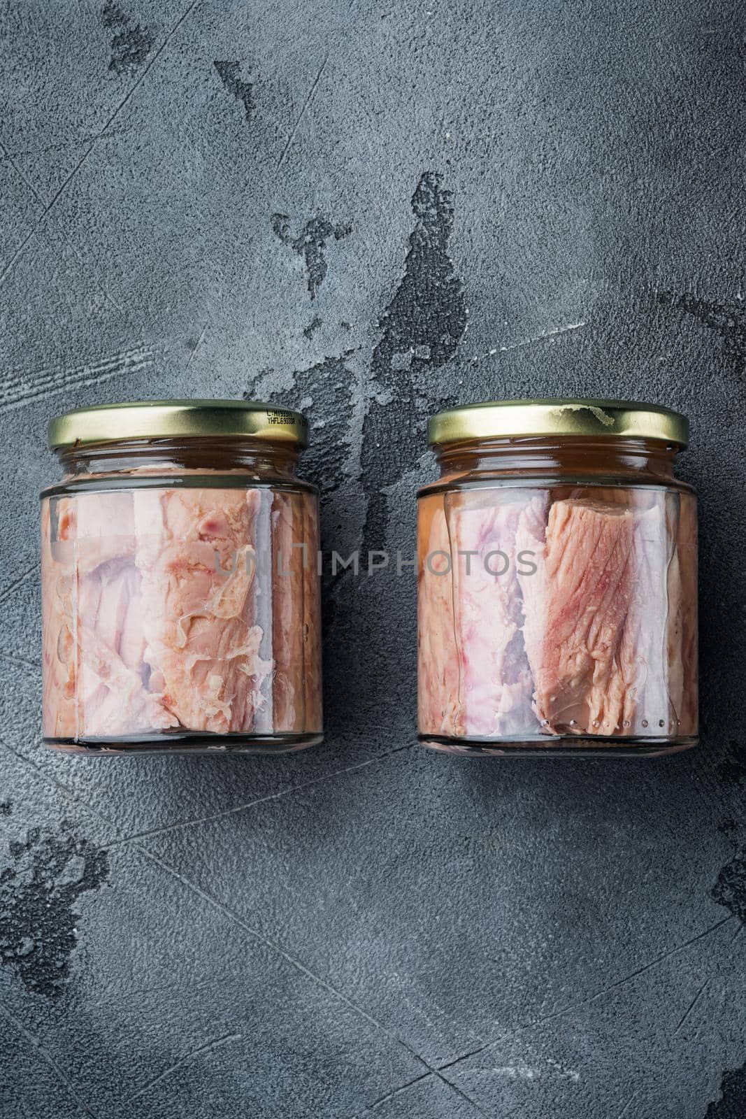 Tuna fillet in glass jar, on gray background, flat lay by Ilianesolenyi