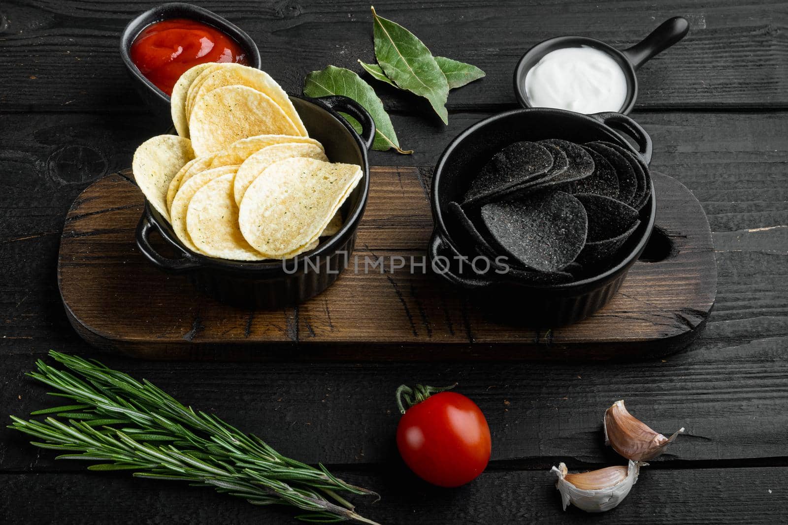 Home made potato chips set, on black wooden background