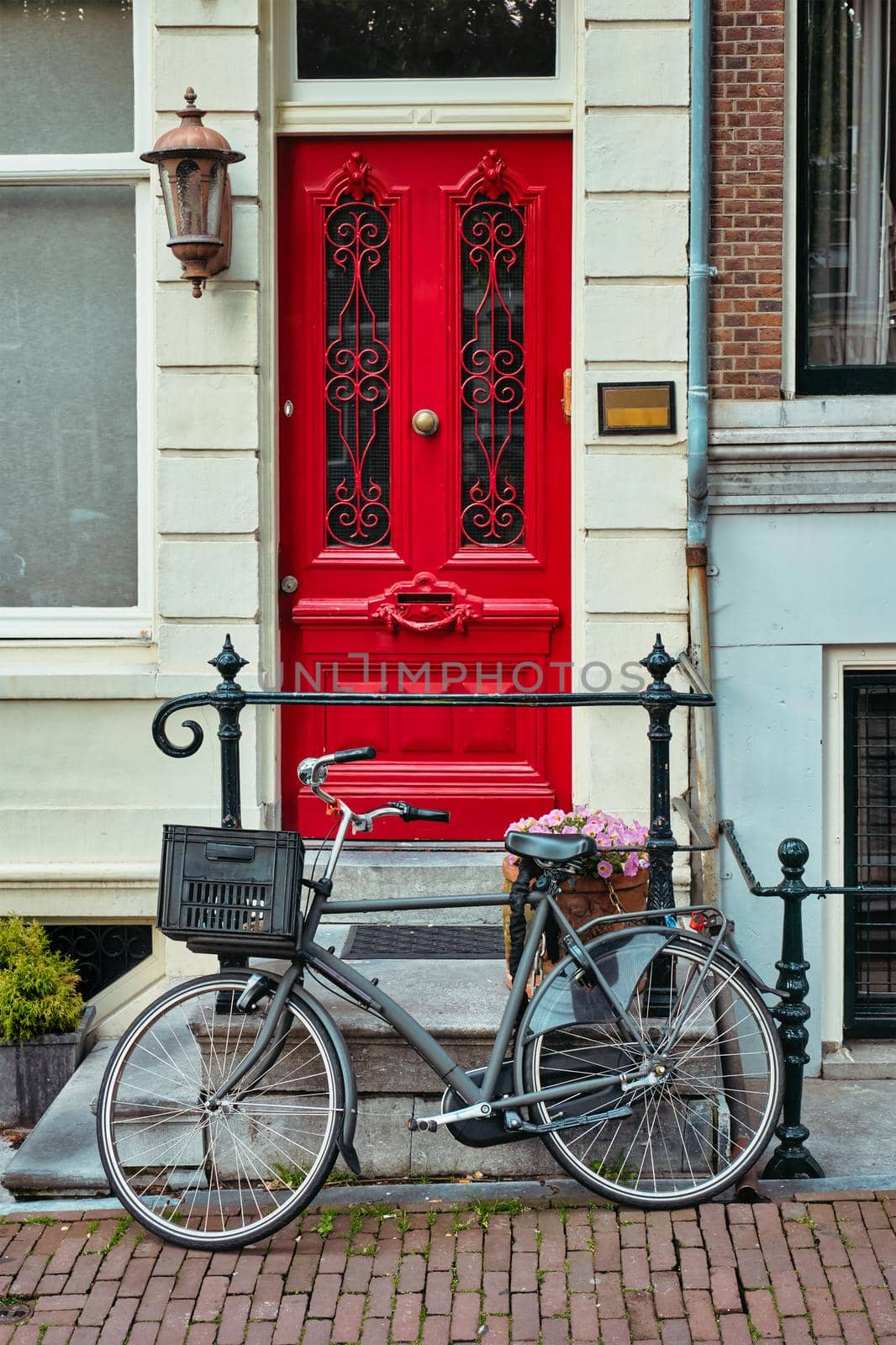 Bicycle near door of old house in Amsterdam street. Bicycles are the very popular means of transport in Netherlands. Amsterdam, Netherlands