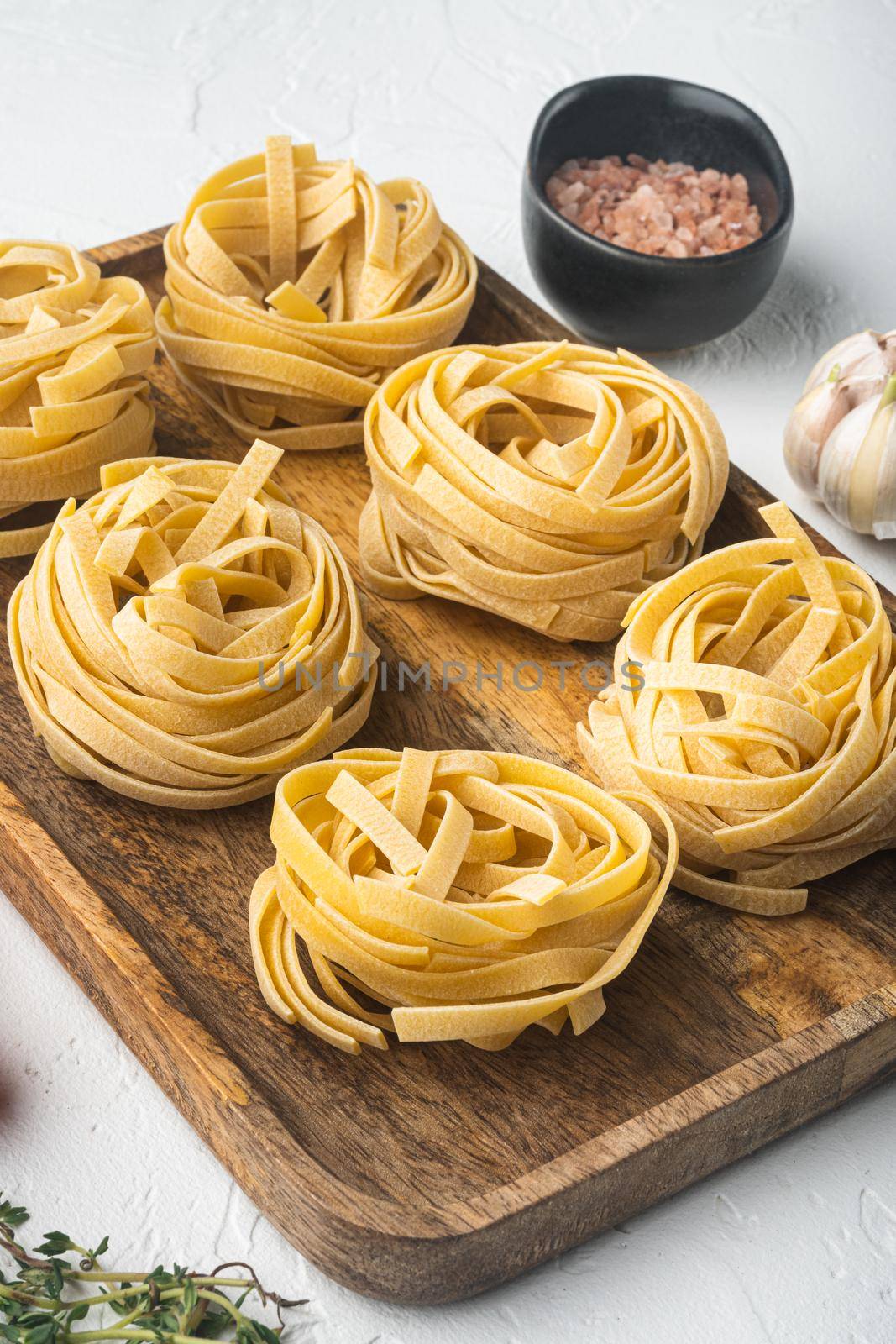 Pasta ingredients Tagliatelle with Italian food ingredients, on white stone background by Ilianesolenyi