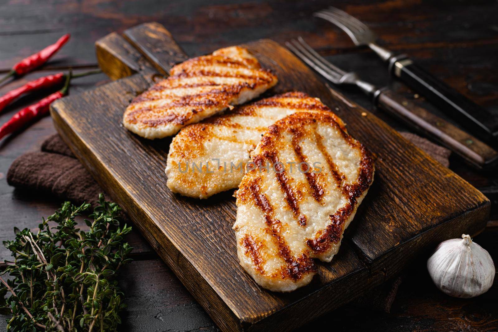 Pork meat schnitzel, on old dark wooden table background by Ilianesolenyi