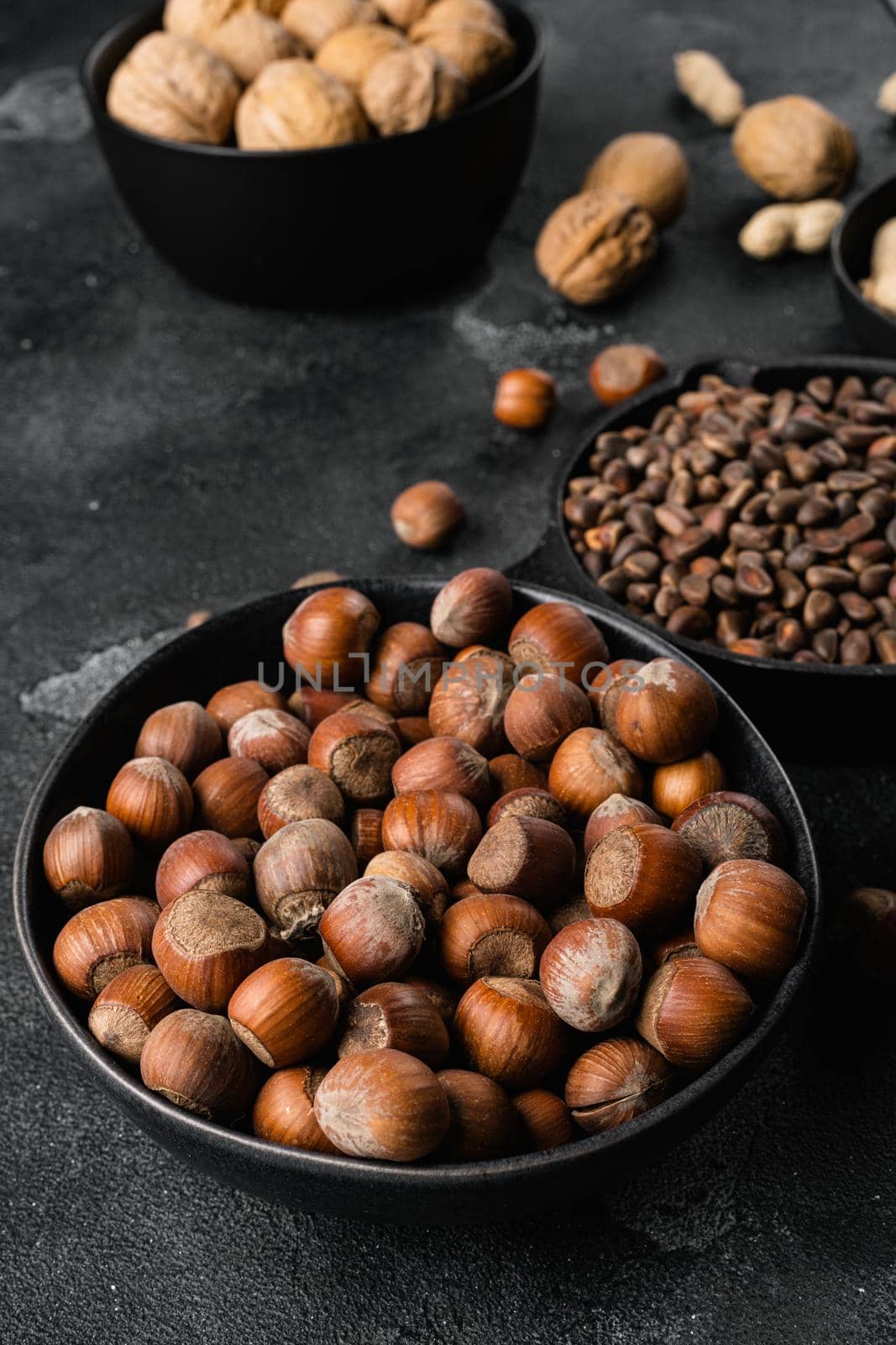Organic Hazelnut whole nuts, on black dark stone table background by Ilianesolenyi