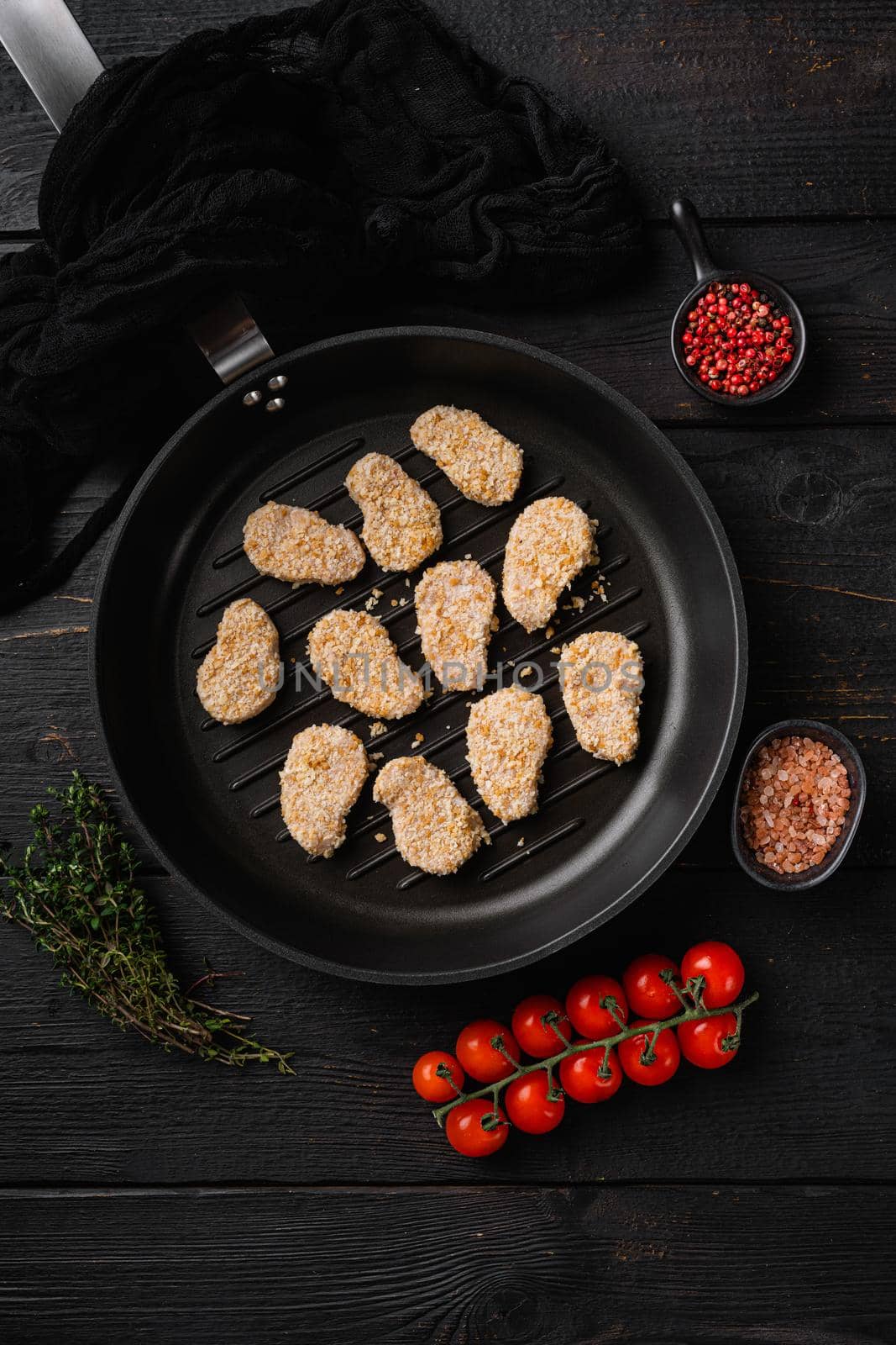 Instant food raw chicken nuggets ready for cooking, on black wooden table background, top view flat lay