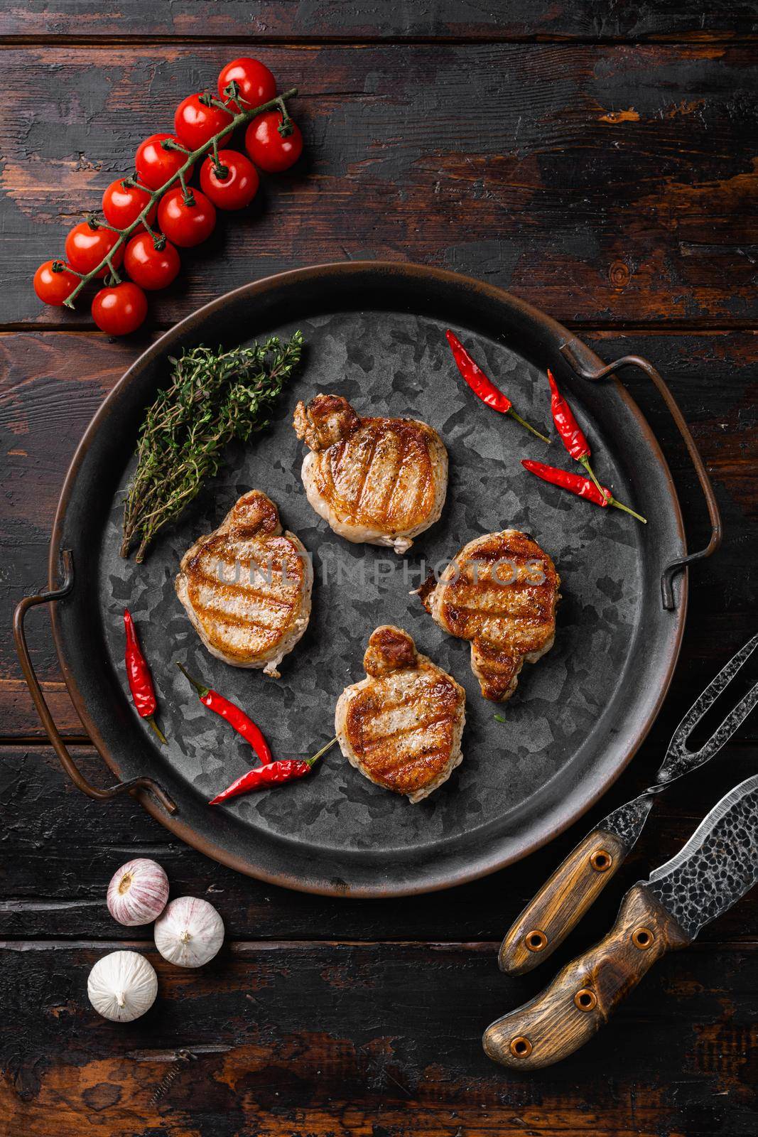 Baked pork fillet loin, on old dark wooden table background, top view flat lay