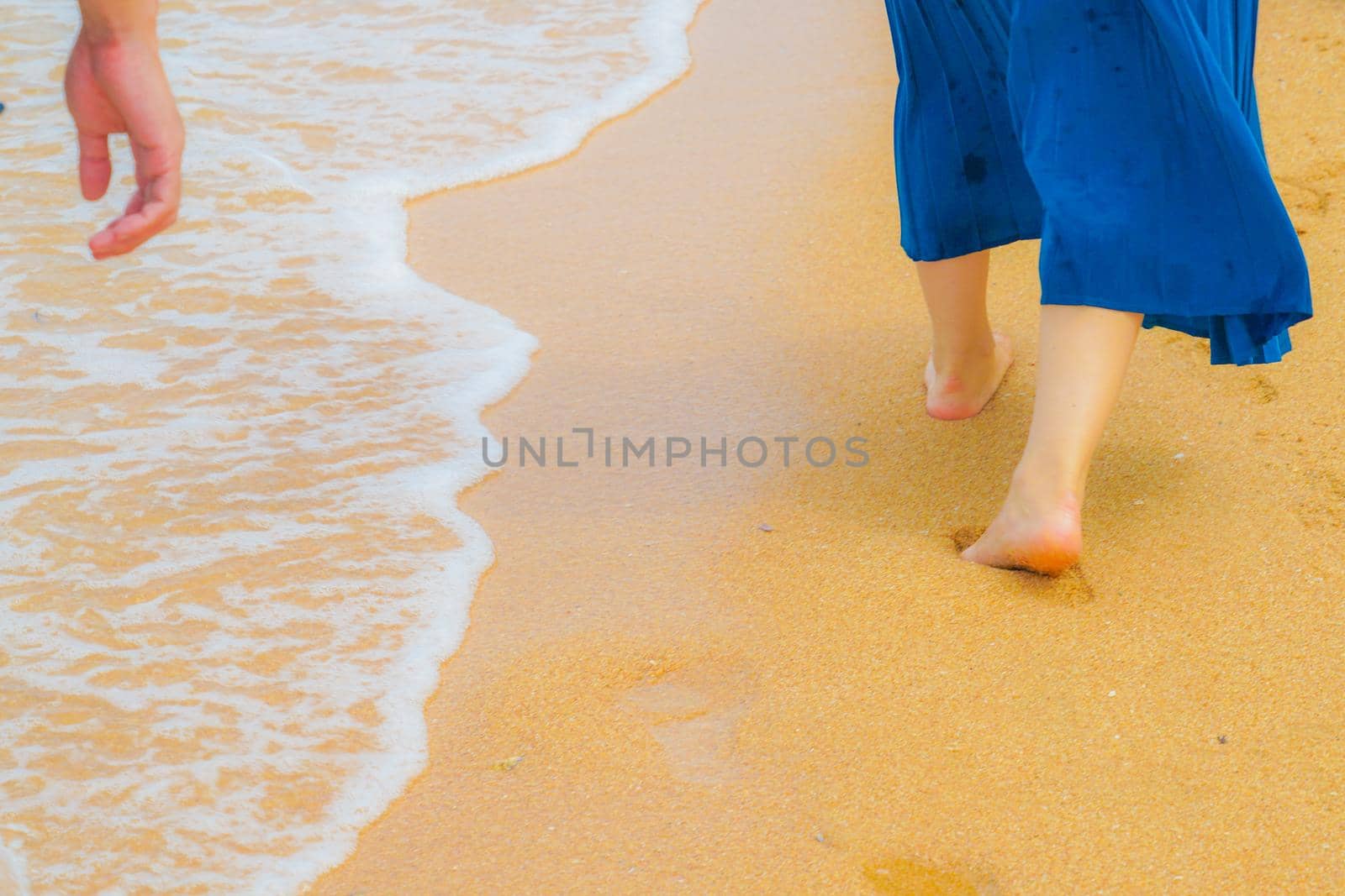 Woman foot walking in the sandy beach. Shooting Location: Thailand, Pattaya