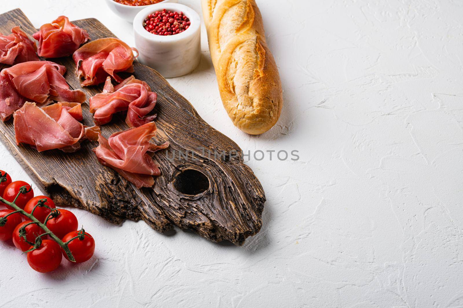 Fresh slices jamon set, on white stone table background, with copy space for text by Ilianesolenyi