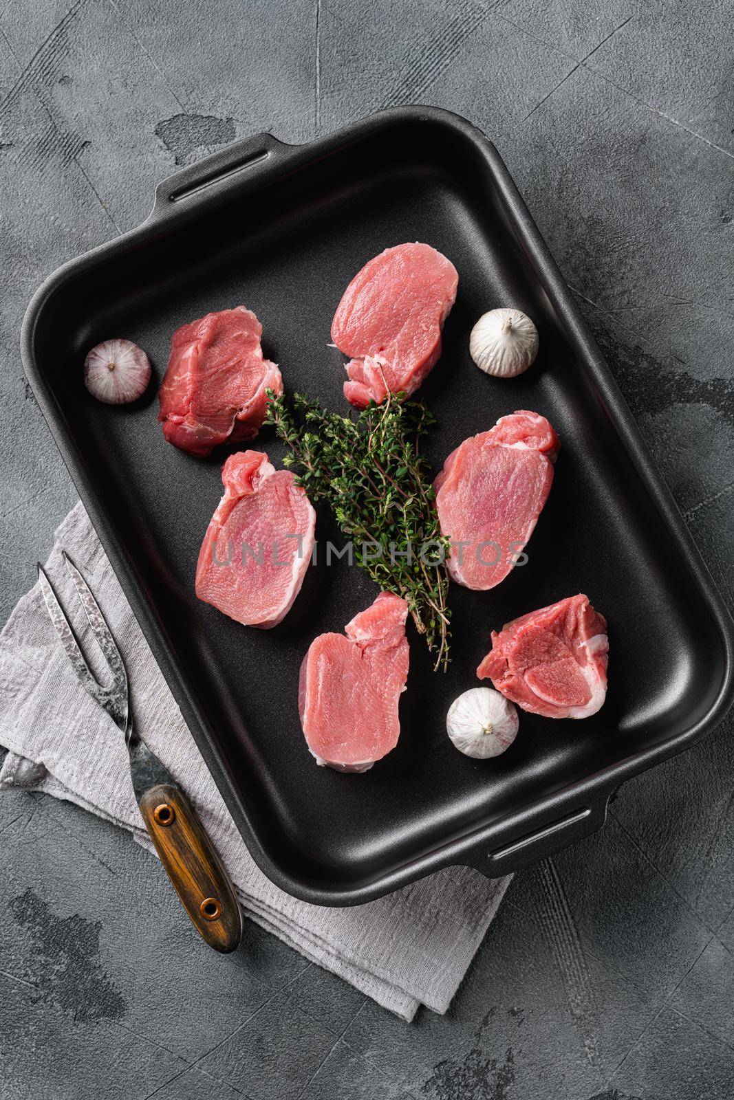 Pork tenderloin. Fresh raw meat prepared for cooking, on gray stone table background, top view flat lay