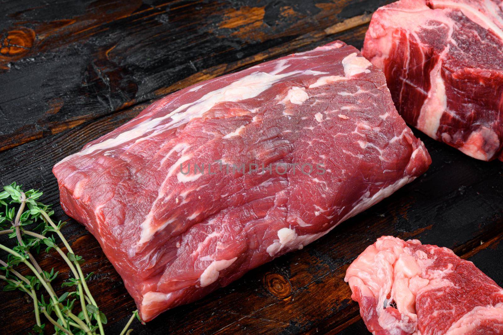 Fresh and raw fillet meat. Whole piece of beef tenderloin steaks, on old dark wooden table background by Ilianesolenyi