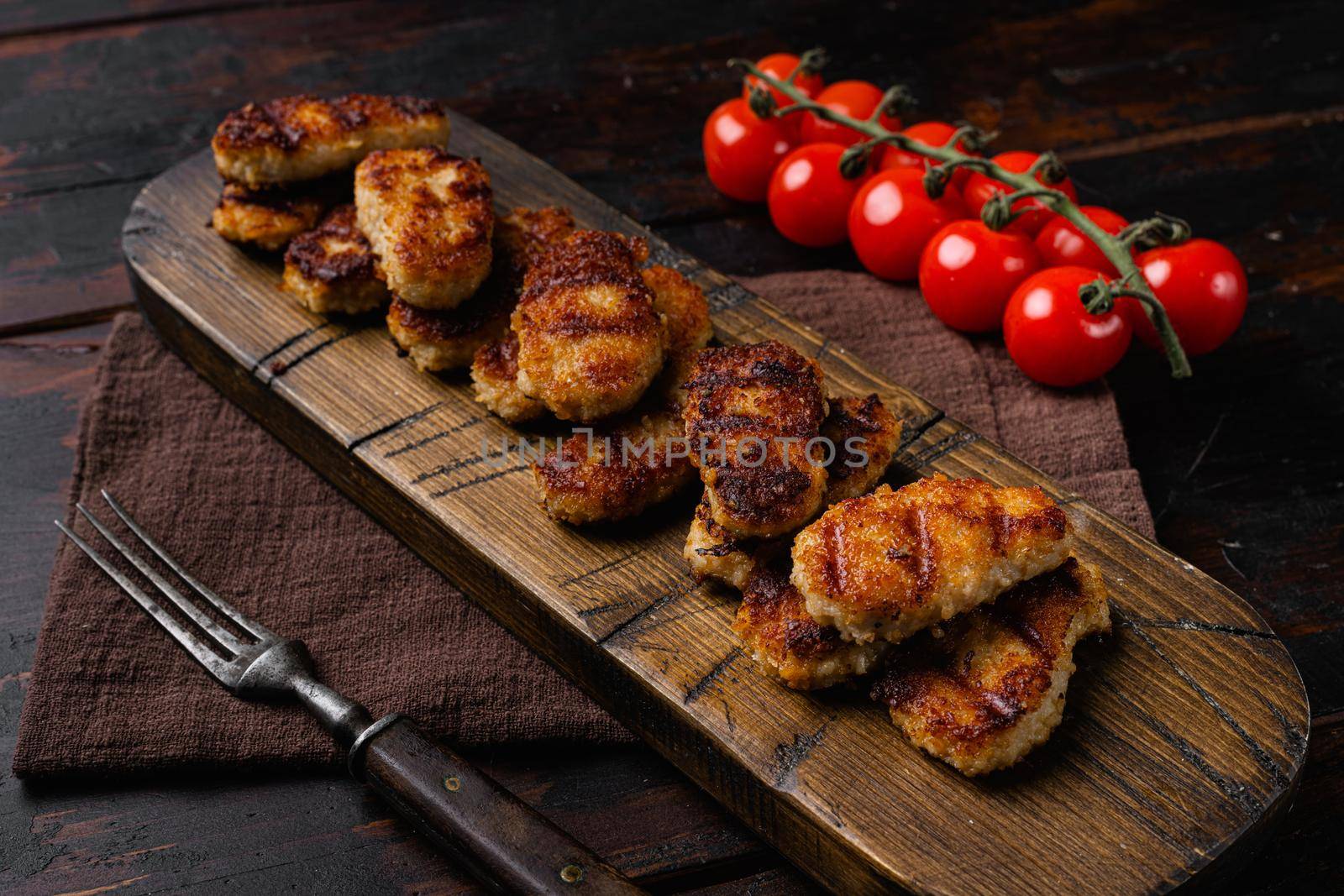 Fried crispy chicken nuggets, on old dark wooden table background by Ilianesolenyi